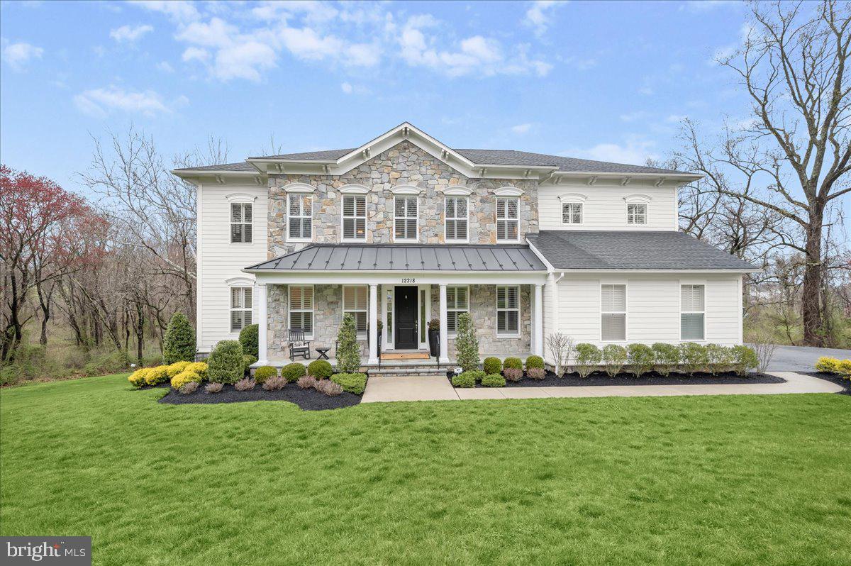 Welcome to one of the finest luxury homes to hit the market in Howard County in quite some time. Located in the exclusive enclave of Highland Reserve, no expense has been spared on this Mitchell & Best masterpiece built in 2018. Boasting 5 bedrooms, 4.5 bathrooms and 6,971 total square feet, this Berkley Floorplan is sited on nearly an acre of land completely surrounded by breathtaking conservation area making the grounds feel expansive and manor-like. This estate features thoughtfully crafted, beautiful outdoor spaces on every level and is zoned for top-tier Howard County schools.

The highlights of the stunning open-concept main level include a double-sided fireplace shared by the screened-in patio, wide-plank hand-scraped hardwood flooring, plantation shutters and two sets of staircases. The kitchen is appointed with a Sub-Zero refrigerator, a Wolf 6-burner cooktop, double oven, quartz countertops and designer pendant lighting. The butler pantry contains its own beverage fridge and leads to the dining room complete with designer chandelier, wallpaper and custom trim work.

A large landing area and loft await at the top of the main staircase on the upper level. The primary bedroom features its own sitting area, covered balcony, and two expansive walk-in closets with custom organizers, one with a jewelry desk and dressing island. The primary bathroom is a spa-like retreat containing a dual shower head frameless shower, two large vanities and a free-standing tub. The secondary bedrooms share a buddy bath, while the guest bathroom features its own en suite bathroom, also with a frameless shower.

You’ll find another bedroom with a large walk-in closet and full bathroom featuring even more designer finishes on the lower level. The large recreation room boasts a media area with built-in surround sound speakers, a large wet bar with beverage fridge and dishwasher, and a gym with rubberized flooring all leading to the impressive patio spaces outdoors. The gorgeous stone paver patio with built-in fire pit provides the perfect backdrop for entertaining. There’s a summer kitchen with granite countertops, custom lighting and a pergola. And the Trex deck features a lighted curved staircase and railings. 12218 Pleasant Springs Court is elegance…defined.