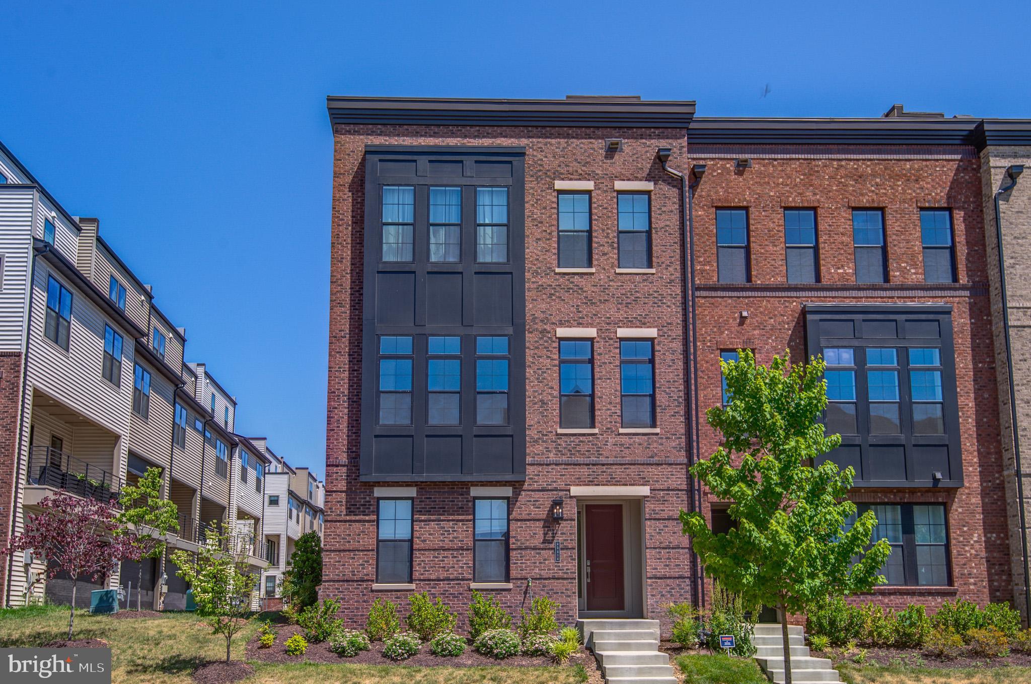 MODERN LIVING MEETS ROOFTOP LIVING - BETTER THAN NEW IN THE HEART OF ASHBURN!!

Experience elevated living on Grandmoore Street, where contemporary elegance, sophisticated design, and exceptional craftsmanship come together to create a truly remarkable residence. This stunning 4-level luxury end townhome offers the perfect blend of style, comfort and functionality, delivering a lifestyle that is both refined and effortless.
From the moment you enter, you will be captivated by the home's light-filled interior, soaring ceilings and sleek modern finishes. On the entry level you will find a large ensuite - bedroom & full bath. The expansive open-concept main level is designed for both entertaining and every day living - featuring a breathtaking gourmet kitchen with an oversized island, premium stainless-steel appliances, designer cabinetry, and striking finishes. 

Designed to impress and at the heart of the home lies a stunning gourmet kitchen the dream of the most discerning culinary enthusiast. One can easily imagine celebrated chef Bobby Flay feeling right at home in this exceptional kitchen, inspired to create memorable meals while gathering family and friends around its inviting centerpiece. This true showpiece features walls of white ceiling height cabinetry accented by brushed-gold hardware creating a timeless blend of elegance and modern design.
The living area features a media wall with fireplace.

Custom designer lighting has been thoughtfully incorporated throughout the residence, adding warmth, sophistication, and architectural interest while elevating every space.

Just off the main living area, a spacious private balcony provides a seamless extension of the indoor living space, creating the perfect setting for morning coffee, al fresco dining or evening cocktails & conversation.
Walls of windows bathe the living spaces in natural light, creating an inviting ambiance throughout. 
Conveniently there is a half bath on this main level.

The luxurious owner's suite serves as a private sanctuary, complete with spa-inspired bath and lavish, boutique-style walk-in closets.  Spacious secondary bedrooms and versatile living areas provide flexibility for guests, a home office or fitness space.  The laundry center provides generous cabinetry with a front load Whirlpool washer/dryer.

The spectacular fourth level  loft is a true standout, offering a stunning flex space complete with a stylish  wet bar and a convenient guest bath. Perfectly suited as a media room, game room, private lounge, home office or a casual entertaining area.  This upper level retreat seamlessly extends to the home's crown jewel - a private rooftop terrace. Whether hosting unforgettable gatherings, enjoying sunset cocktails or stargazing, this extraordinary indoor-outdoor living experience creates a lifestyle rarely found in townhome living.

Perfectly positioned in one of Ashburn's most desirable locations, residents enjoy convenient access to upscale shopping, acclaimed dining, parks, recreation, major commuter routes, and the Silver Line Metro.  Combining modern luxury, exceptional entertaining spaces and an enviable location, this better-than-new residence presents a rare opportunity to enjoy the very best of Northern Virginia living.