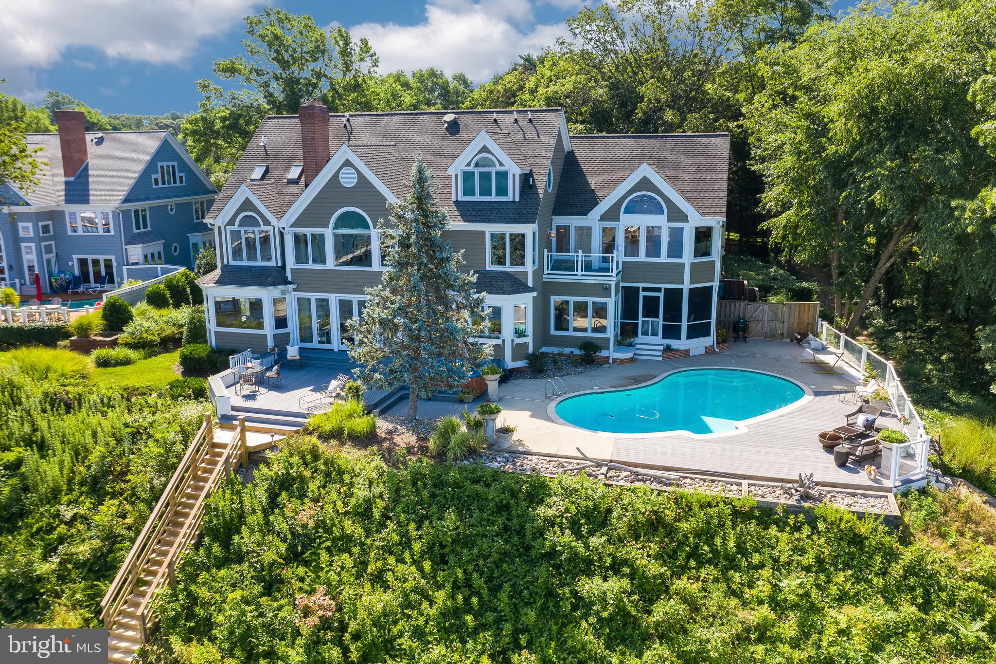RARE OPPORTUNITY TO OWN A SPECTACULAR RIVER FRONT ESTATE IN A HIGHLY SOUGT AFTER LOCATION. Breathtaking panoramic views with western sunset exposure. Elegant and private setting and graciously sited on .62 acres. You will love the waterside, saltwater heated pool and spa with ample decking and unobstructed views of the Magothy River/Forked Creek and Cool Springs. 128 Feet of water frontage, bulkhead and deep-water private dock with two lifts. Enter this beautiful home through your custom, cherry wood double doors to view straight down the Magothy River.  Over 6000+ square feet on 4 levels with waterside office, large crown molding and screened porch for al-fresco dining and lounging.   This 5BR, 6FB home has an elegant coastal / transitional style with open floor plan and private bath for each bedroom. The Owner's suite has a lovely elevated water view, cozy gas fireplace, remote controlled black out blinds and walk-in closet with washer / dryer.  Gorgeous waterside 3rd floor TV/family room above the garage is a wonderful second family space with gas fireplace and rolling library ladder to access the fourth floor balcony. Fabulous renovated basement with new kitchen, bedroom and full bath that is perfect for guests, nanny or in-law suite. Beautifully landscaped with a tree-lined drive showcasing cherry trees, evergreens, boxwoods and perennial tulips. Teaming with year round visual interest from a variety of boats passing by, Chesapeake Bay wildlife and Wednesday night sailboat races.  All can  be seen from just about every room in your home! Located in a highly sought after community of fine homes and close to all major commuting routes, restaurants and shopping. Ulmstead offers a multitude of social events, 2 marinas, a pool, clubhouse, horse facilities; tennis/pickleball courts ball fields and a waterfront beach park! Just 5 miles to downtown Annapolis and Severna Park, and convenient to Baltimore, BWI, Ft. Meade/NSA and Washington, DC.