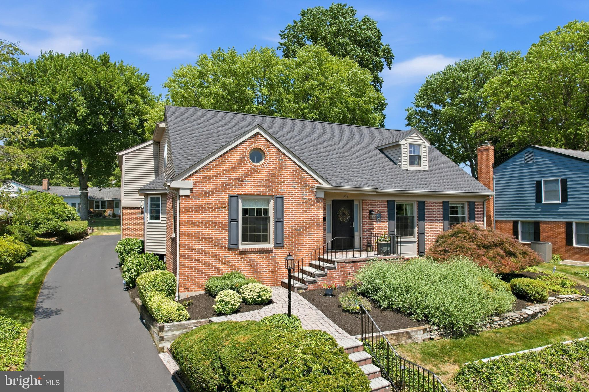Rarely does a home come to market that offers this much space, flexibility, and thoughtful updating in one of North Wilmington's most desirable neighborhoods. Welcome to 319 Hampton Rd in the sought-after Brandywine Hundred community of Sharpley, where timeless charm meets modern convenience across 3,675 square feet of beautifully maintained living space. From the moment you arrive, the home's classic brick front, mature landscaping, and inviting paver walkway create exceptional curb appeal. A covered front entrance welcomes you inside to a tiled foyer featuring an exposed solid hardwood staircase, and an abundance of natural light that immediately sets the tone for the warmth found throughout the home. Designed with both everyday living and entertaining in mind, the spacious formal living room offers an elegant gathering space, while the formal dining room showcases hardwood flooring, a stylish chandelier, chair rail molding, and large windows that fill the room with sunlight before flowing seamlessly into the heart of the home. The beautifully renovated chef's kitchen is sure to impress. A bay window bump-out above the sink brightens the space, while the oversized breakfast bar island with a gas cooktop creates the perfect spot for casual meals or entertaining guests. Granite tops, stainless steel appliances, crown molding, recessed lighting, a wine bar nook, and generous pantry storage complete this exceptional space. Just beyond the kitchen, the inviting family room provides a cozy retreat highlighted by rich hardwood flooring, recessed lighting, a striking fireplace, and an attractive stone accent wall. The adjoining sunroom offers a peaceful escape overlooking the backyard, making it an ideal place to enjoy your morning coffee or unwind at the end of the day. One of the home's most desirable features is the spacious first-floor bedroom suite complete with a full bath and conveniently located laundry area. Whether you're looking for an in-law suite, first-floor primary bedroom, private guest accommodations, or a dedicated home office, this versatile space offers endless possibilities. A well-appointed powder room and interior access to the attached two-car rear-entry garage complete the main level. Upstairs, the massive (23’x20’) primary suite addition serves as a true private retreat. Vaulted ceilings, recessed lighting, custom shelving, a sitting area, and an expansive walk-in closet create a luxurious atmosphere. The modern spa-inspired ensuite bath features tile flooring, dual sinks with a quartz vanity top, a beautifully tiled shower, and a corner soaking tub perfectly positioned beneath a window for relaxing at the end of the day. Three additional generously sized bedrooms provide comfortable accommodations, each offering ceiling fans, ample closet space, and abundant natural light. The updated hall bath features an attractive vanity and a spacious tub/shower combo with tile surround. The finished basement expands the home's versatility with extensive cabinet storage, a large unfinished storage area, and an additional finished room ideal as a home office, fitness area, media room, or hobby space. Outside, the low-maintenance lot offers plenty of open green space for children and pets, along with the added bonus of an in-ground basketball hoop for endless outdoor fun. The long driveway and attached two-car garage provide ample parking for family and guests alike. Significant recent improvements provide added peace of mind, including a new roof installed in 2025, a new HVAC system in 2023, and replacement windows throughout the home in recent years. Located just moments from shopping, dining, major commuting routes, and the DuPont Country Club, this exceptional home combines generous living space, quality updates, and an unbeatable location. Opportunities like this in Sharpley are rare. Schedule your private tour today and discover everything 319 Hampton Rd has to offer.