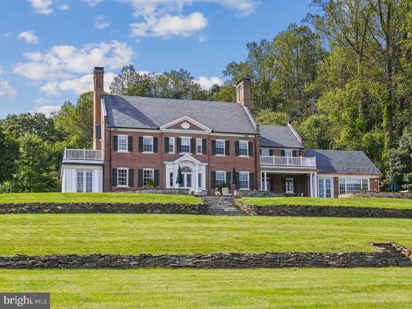 Welcome to Three Ponds, a 14-acre estate tucked away in historic Caves Valley.  The newly renovated Georgian home is perched on a hill overlooking fields, wooded areas, three ponds, and a three bedroom, three bath guest home. At over 10K square feet, the main house has 5 bedrooms, 4 full, and 3 half baths. This includes a private 1 bed/ 1 bath guest suite above the oversized 2 car garage. The home is fully wired for sound and has a state-of-the-art security/sound system as well as main level and bedroom level laundry rooms. The brand-new kitchen boasts a full-sized walk-in butler’s pantry, two large quartz islands, white oak floors, a Wolf 6 burner range with griddle, grill, and 2 ovens, a Sub-Zero fridge, ice maker, coffee/wet bar, 2 dishwashers, custom shades, and French doors that open to the outdoor terrace, which overlooks the valley. Perfect for entertaining, the main level also provides a lounge with a wet bar, wine fridge, ice maker, wood burning fireplace, as well as an exterior door leading to the covered porch. Additional rooms include a formal living room, a family room, and a sunroom. The basement is finished with a half bath, playroom, and a finished flex room/dry storage with an egress to the exterior. Upstairs, there are 4 bedrooms and 3 full baths, including the primary suite, which has a private deck with valley views, a newly renovated bathroom, and a dressing room. The primary bath includes an infinity blue quartzite double vanity, heated marble floors, a spa tub, a marble steam shower with a built-in bench, dual shower heads, and a custom marble mosaic. The third floor is a sprawling finished flex space that could be used as a studio, playroom, gym, or even finished into more bedrooms. Just down the hill from the main house sits a pond-side guest house outfitted with a full kitchen, laundry, 3 beds and 3 baths, wrap-around porch, and terrace that looks over the pond and back up the hill toward the main residence.
Other exterior features include a fully fenced Zen garden, a raised vegetable garden, and a fenced pasture/dog run.