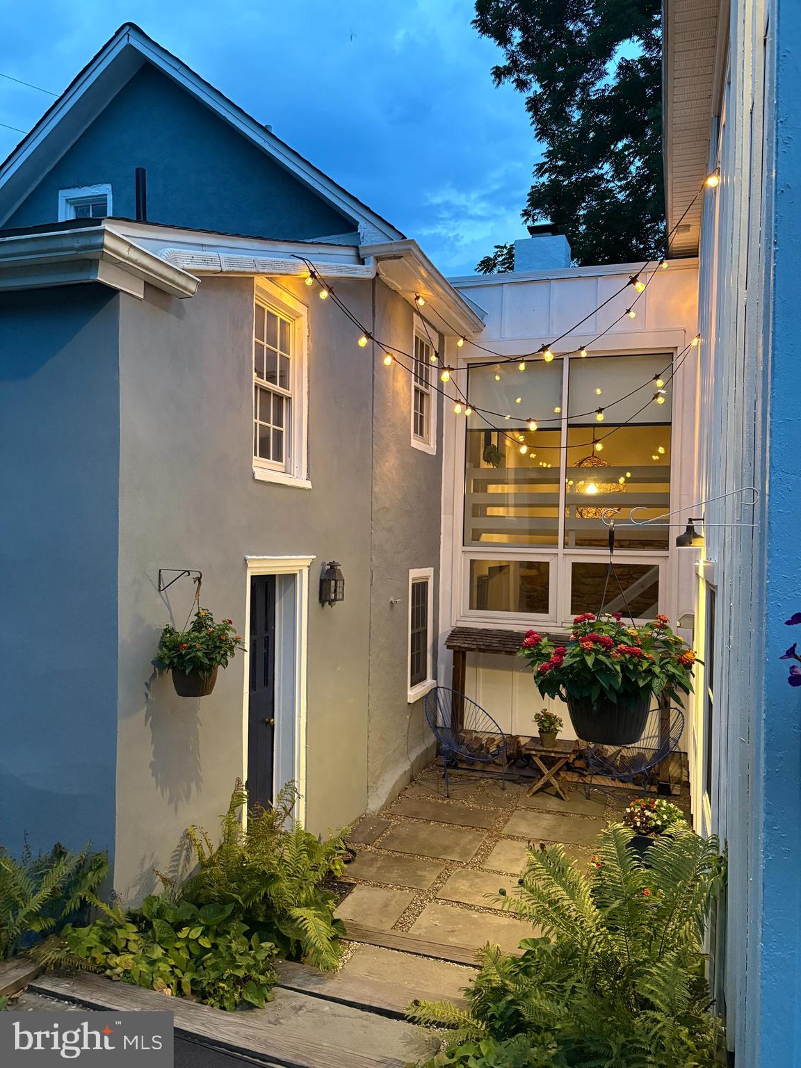 Rarely does a property offer the opportunity to own both a beautifully restored 18th-century Bucks County home and a remarkable light-filled studio with Village Commercial zoning. Originally built around 1739 and thoughtfully expanded in 1973, this one-of-a-kind property has been home to artists for at least the past 75 years. The current owners lovingly restored and reimagined the home, completing an extensive renovation in 2017 that honored its historic character while updating nearly every surface and major system for today's lifestyle. Privately tucked behind a gated entrance, a stone pathway leads to a welcoming courtyard nestled between the original farmhouse and its later addition, creating a peaceful outdoor room that immediately sets the tone for what lies beyond. Inside, centuries-old character blends effortlessly with timeless craftsmanship. Wide-plank antique floors, exposed interior stone walls, hand-hewn beams, rounded window sills, soaring ceilings, and an open staircase connected by a catwalk are just a few of the details that make this home unlike any other. The beautifully renovated kitchen is both functional and artistic, featuring a generous nine-foot seating island, granite countertops, and custom blackened cherry countertops handcrafted from a tree harvested right on the property—a memorable detail that beautifully tells the story of this one-of-a-kind property. Open to the spacious original wood-beamed dining room, the family room serves as the heart of the home, joining the original house and later addition. Filled with natural light from two-story windows, a cozy wood-burning stove adds warmth and character, making it an inviting space to gather.  Nearby, the main-level full bath features a six-foot soaking tub, shou-sugi ban wood paneling, and radiant heat flooring. Also on the main level, you'll find a beautifully designed laundry/mudroom with a brand new laundry tower and an entire Moravian tile floor, adding both character and everyday practicality. Upstairs, the spacious primary bedroom offers a peaceful retreat complete with a wood-burning stove, recessed lighting, and separate closets. One secondary bedroom features a charming hand-painted mural and an adjacent full bath with marble, copper, and brass accents, creating a comfortable and convenient space for guests. The third bedroom is highlighted by a whimsical interior peekaboo window, one of many charming architectural details found throughout the home. A spacious hall bath conveniently serves the primary and third bedrooms. Just beyond the courtyard, a custom-built studio offers nearly 1,000 square feet of light-filled space designed to inspire creativity. Designed and built by the current owners, it is currently used as a woodworking and furniture-making studio but is equally suited for artists, designers, photographers, wellness professionals, entrepreneurs, or anyone seeking an inspiring place to create or work. Thoughtfully designed perennial gardens surround the property with color and texture throughout the seasons. An adjoining parcel provides additional privacy, bringing the total property to just over half an acre, all just minutes from the shops, restaurants, and cultural attractions of Doylestown Borough and the charm of nearby New Hope. Some homes are simply places to live. Others inspire the people who live there. Rich in history, thoughtfully restored and reimagined, this extraordinary property is ready for its next chapter.