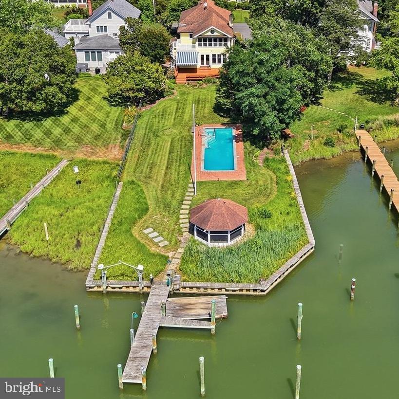 Western sunsets and timeless waterfront living define this beautifully restored home on Town Creek in Oxford. A waterside pool, expansive entertaining deck, gazebo and private pier create an exceptional setting for relaxing, entertaining and enjoying life on the water.
Inside, a gourmet kitchen and inviting family room with a custom built-in bar anchor the home, while warm pine floors add warmth and character throughout. Three bedrooms and three full baths include a spacious waterfront primary suite with a private second-story deck overlooking Town Creek—the perfect place to unwind while taking in spectacular western sunsets.
Just moments from Oxford's waterfront park, marina, restaurants and the Oxford-Bellevue Ferry, this distinctive property is privately sited outside the Historic District and features a private pier with approximately 4 feet of mean low water, providing easy access for boating, kayaking and paddleboarding. Property is offered as part of an estate and is being sold as is.