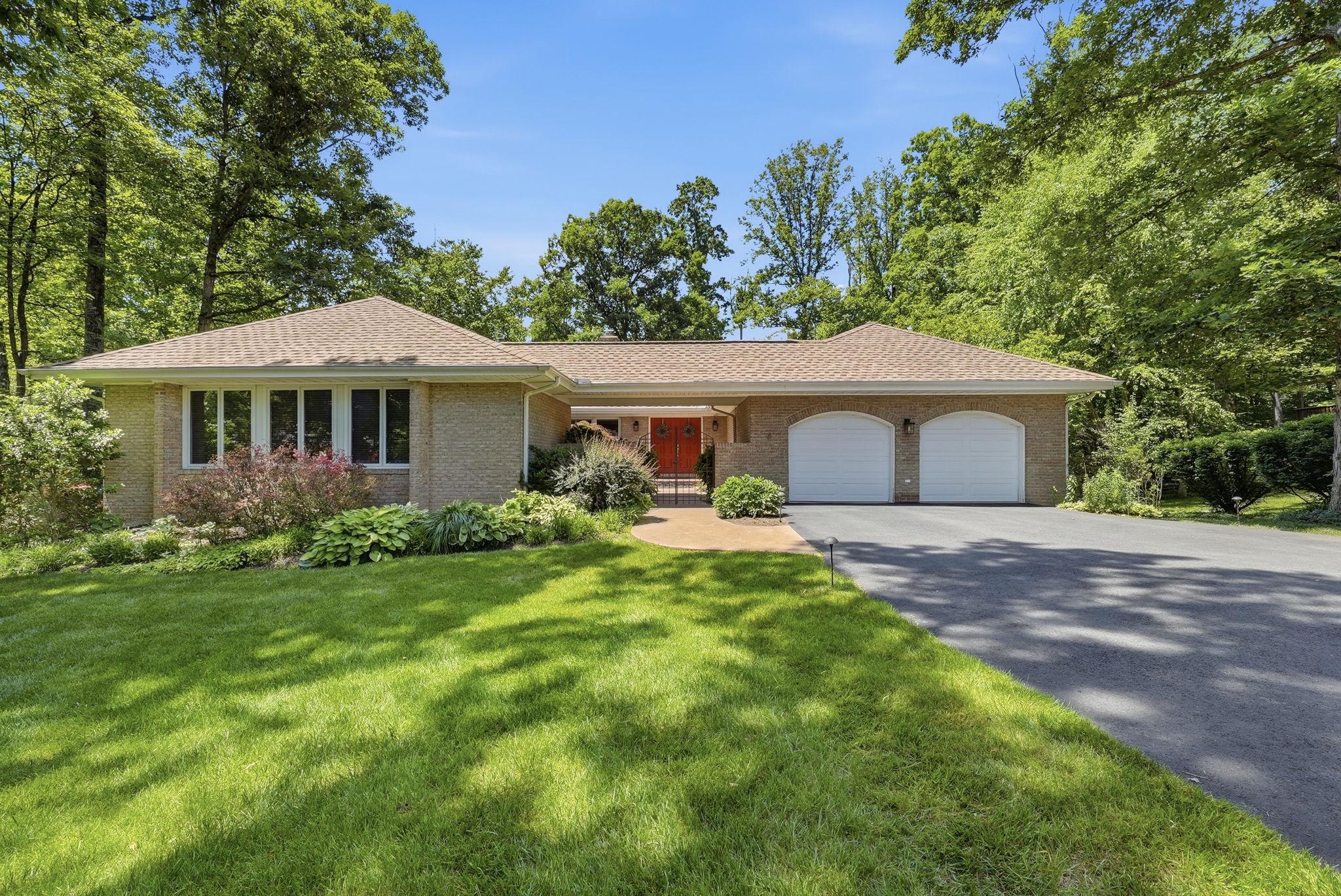 Nestled on a sprawling 0.6-acre treed lot at the end of a quiet cul-de-sac, this quality custom-built home offers luxurious living with 5 bedrooms and 3.5 updated baths. An iron gate leads to impressive double front doors with an impressive Japanese maple tree and beautiful plantings, another touch of quiet privacy. 
The gourmet kitchen is a chef's delight with a breakfast area surrounded by windows and featuring a custom skylight.  Skylights and hardwood floors illuminate the spacious interiors and flow throughout. This home is bright even on a dark weather day.  Cathedral and vaulted ceilings add an airy elegance the main living areas.  Step outside to a large Trex deck that overlooks the serene wooded lot with mature plantings, offering a private retreat.
The formal dining room featuring a gas fireplace set into a brick wall and a formal living room also with a gas fireplace set into a brick wall provides exceptional entertaining possibilities.  Beautiful owners suite with tray ceiling, sliding glass doors to the deck, and a spa-like bath provides an oasis with a separate soaking tub and a large, rainforest-style shower, heated floor and Toto toilet, complemented by walk-in closets.
The walk-out basement includes a kitchenette, two large bedrooms, walk-in closets, renovated full bath and large rec room with sliding glass doors to the backyard.  The perfect haven for guests or extended family. An incredible workshop offers plenty of room for hobbies or storage. 
Convenience is key in this amazing home with multiple sliding glass doors allowing easy access to the rear deck.  In-ground irrigation for ease of yard care. The two-car garage is equipped with an EV charger.
Enjoy access to an array of community amenities, including a pool, pond, tennis/pickleball courts, tot lot, basketball court, and biking/jogging/walking trails.  Close to Burke Lake and South Run Recreational Center. Don't miss this amazing home!  Perfection does exist!!! A long list of MAJOR  renovations/replacements can be found in Documents and available at the property.