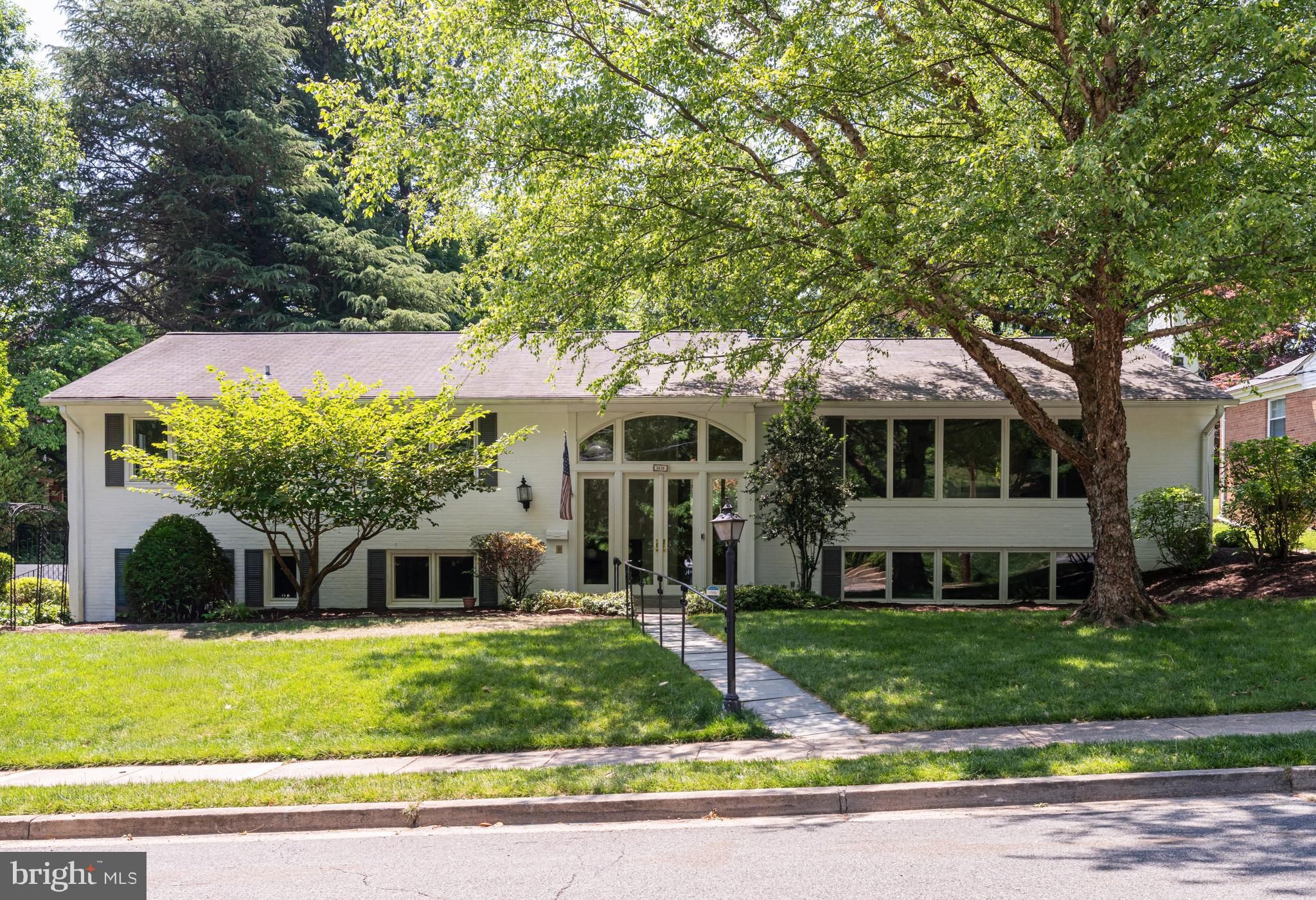 Tucked away on a lush half-acre lot in Arlington’s coveted Bellevue Forest neighborhood, this beautifully renovated brick split foyer offers a rare blend of architectural character, privacy, and modern design. Framed by mature trees and thoughtfully landscaped grounds, the property feels more like a private retreat than a traditional suburban home — where mornings begin with coffee in the sun-drenched skylit sunroom, afternoons flow effortlessly onto the rustic flagstone patio and expansive backyard, and evenings gather around one of two wood-burning fireplaces beneath the glow of designer lighting and soaring windows. 

Inside, the home embraces a refined post-modern aesthetic, pairing clean lines, dramatic glass, warm textures, and curated finishes with flexible living spaces designed for the way people live today. The dramatic two-story entry creates an immediate sense of openness, while oversized windows and skylights fill the home with natural light throughout the day. The main level is arranged to support both everyday living and entertaining, with hardwood flooring extending throughout the primary living spaces. The large kitchen, open to the adjacent breakfast room, becomes the natural center of daily life — equally suited for casual mornings, intimate dinners, or entertaining that spills seamlessly between indoor and outdoor spaces. 

The bedroom wing offers a quiet, private retreat with two secondary bedrooms, a fully renovated hall bath and a large primary suite with brand new spa-inspired bath, featuring dual vanities, led mirror and walk-in shower. Downstairs, the expansive lower level creates exceptional flexibility with large recreation and lounge spaces, two additional bedrooms, office or studio potential, and guest accommodations ideal for multigenerational living, work-from-home lifestyles, fitness, media, or creative use. 

Located inside the Beltway and set within the Yorktown High School pyramid, this home combines flexible living spaces, inviting gathering areas, and a highly connected location with quick access to Washington, DC, parks, trails, Ballston, and major commuter routes.  Don’t miss this rare opportunity to own a turnkey architectural home on an oversized lot — offering both the convenience of the city and the feeling of living immersed in nature.