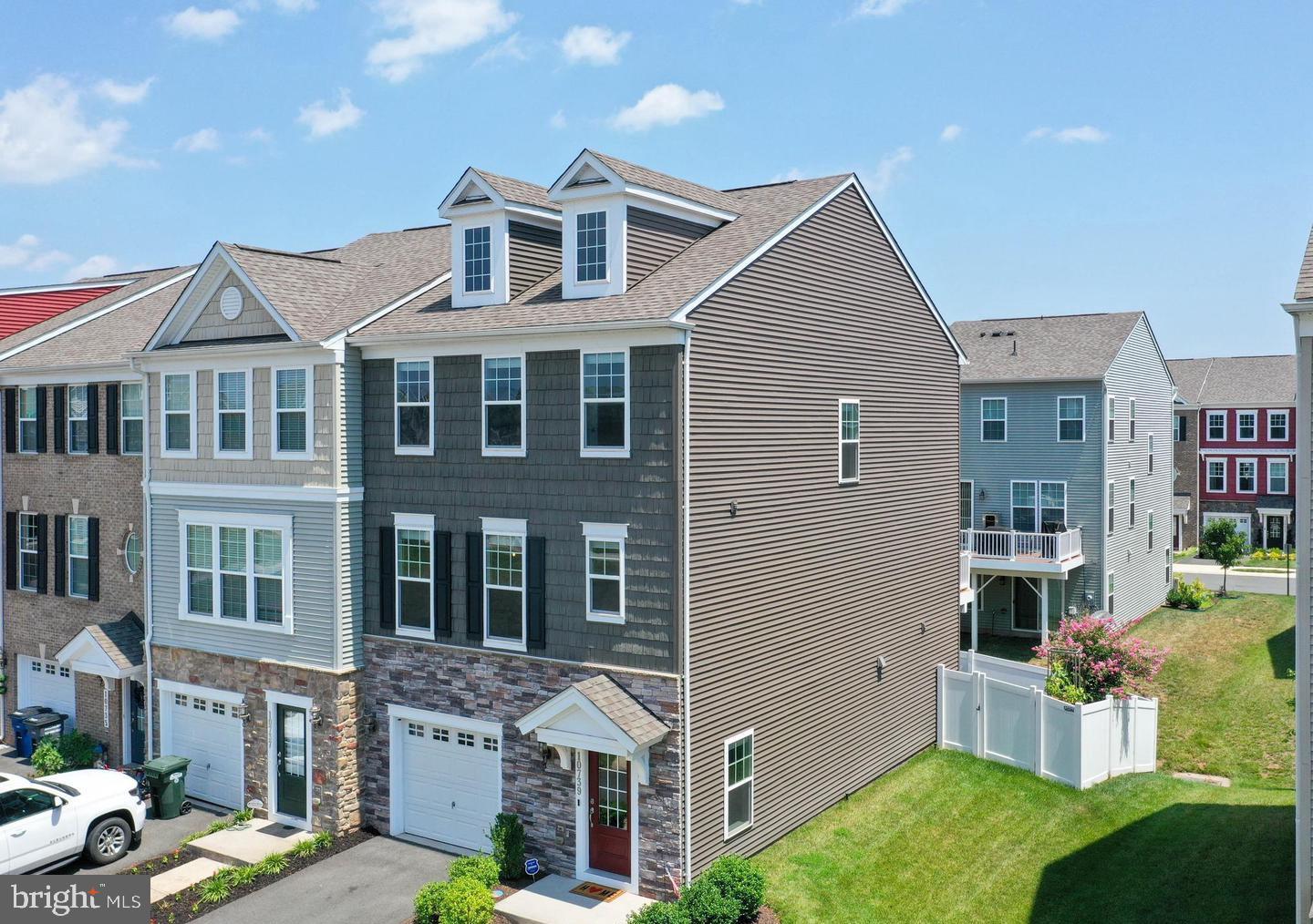 Welcome to Bradley Square Community- where refined comfort meets everyday convenience just minutes from the VRE and the charm of downtown Manassas. This impeccably upgraded, nearly 2,300-square-foot townhome offers a polished blend of modern design and thoughtful functionality, creating a residence that feels both elevated and inviting. Refrigerator, Dishwasher and Microwave purchased in 2024.
Outdoor living is equally compelling, featuring a beautifully designed, multi-level paver patio with partial shade and privacy fencing—perfect for relaxing or entertaining—along with a spacious main-level deck finished with sleek vinyl railings.
Inside, the home is defined by soaring ceilings, and abundant recessed lighting that enhances the home’s bright, open ambiance. The entry level welcomes you with a grand foyer and a versatile bonus space—ideal as a fourth bedroom, guest suite, or home office—complete with a full bath and direct backyard access. 
The home also features a fully finished garage designed for both functionality and modern living, complete with a sleek epoxy-coated floor, custom heavy-duty shelving for optimal storage, and a 240V electric vehicle charger—perfect for convenient at-home charging.
The main living level is designed for seamless entertaining, anchored by a chef-inspired kitchen featuring granite countertops, a generous center island, double ovens, a walk-in pantry, and stainless steel appliances. The adjoining dining and family rooms create a fluid, open-concept space perfect for gatherings or quiet evenings at home.
Upstairs, you’ll find three well-appointed bedrooms and a conveniently located laundry area. The primary suite serves as a true retreat, offering dual walk-in closets and a spa-like en-suite bath with a beautifully tiled shower and double vanities. Secondary bedrooms are generously sized, each with ample storage and easy access to a stylish full bath.
Perfectly positioned overlooking community green space and a pavilion, this home offers a tranquil setting with access to exceptional neighborhood amenities, including walking trails, an outdoor fitness area, splash pad, playground, and year-round community events.
With HOA services covering landscaping and trash, and close proximity to shopping, dining, major commuter routes, and the vibrant events of Manassas, this residence delivers a lifestyle of ease and sophistication. A rare opportunity to own a home that truly has it all—style, space, and an unbeatable location.