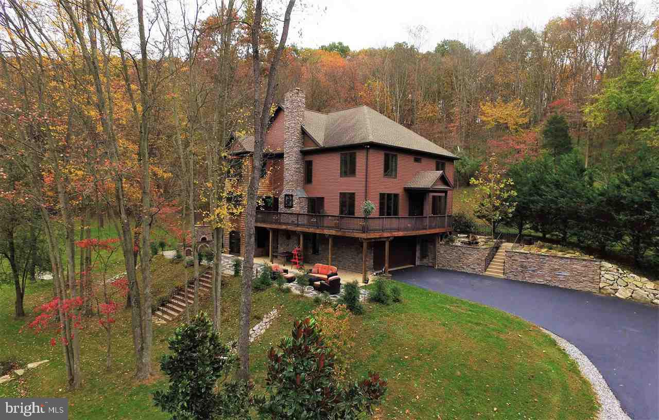A Private Oasis!  Custom 4BR 3.5FB on 6.68 Ac.  Spacious, bright & Light, open floor plan. Great Rm w/hdwd, vaulted ceilings, flr to ceiling fireplace, views from every window. Kitch w/Granite, SS, Breakfast Rm. 1st Flr BR w/FB.  Lvl 2 w/Loft Area, Mstr BR Ste, 2 spacious BRs. Lvl 3 for storage or playroom.  Fin LL w/wood stove, Kitchen area leading to Patio with custom Brick Oven.  Wildlife is abundant. Close to everything! Inc. Adjoining Lot