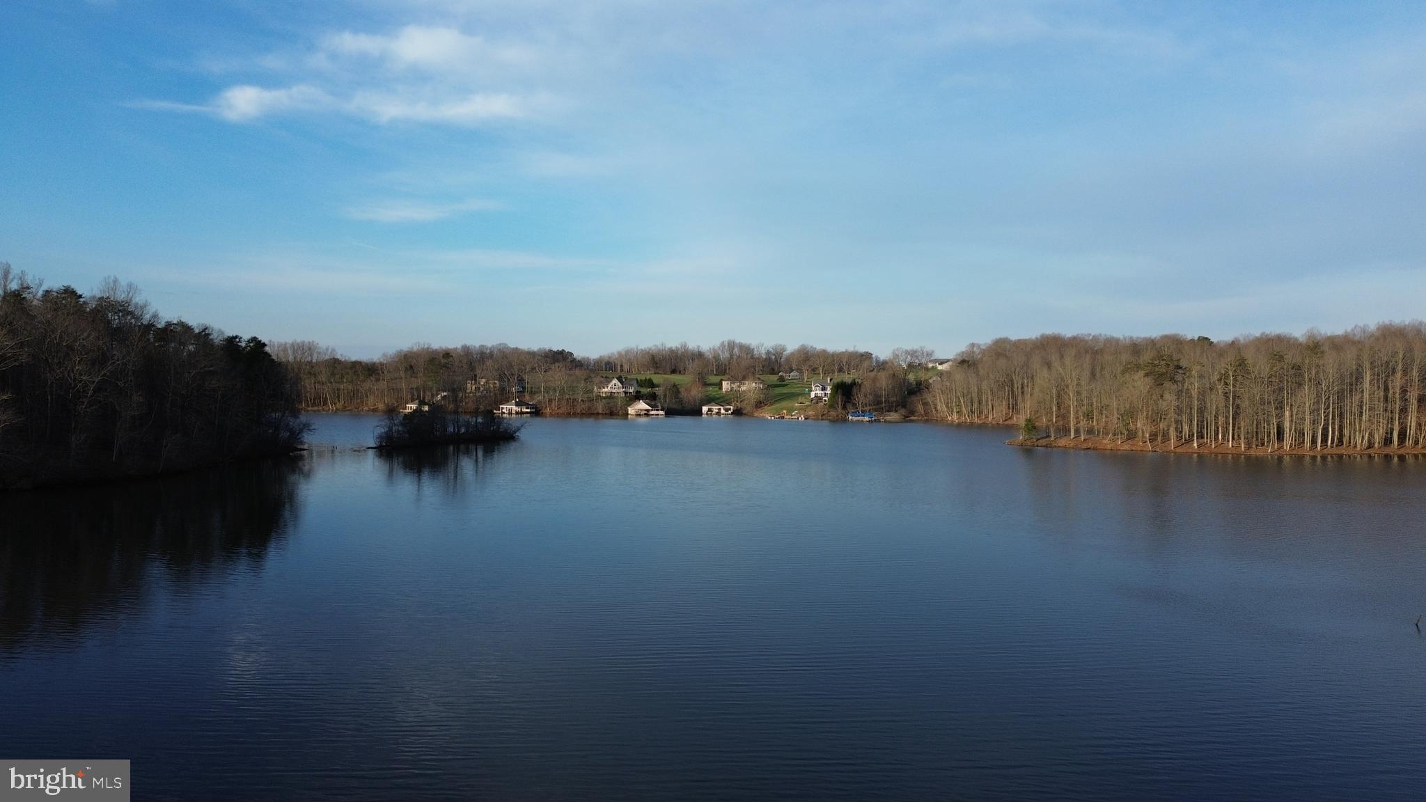 A rare opportunity to own 12.19 contiguous waterfront acres on Lake Anna, featuring approximately 398± feet of exclusive shoreline rights, sweeping water views, and exceptional privacy.

Imagine winding down your own long private driveway toward a rare stretch of Lake Anna shoreline, where the property opens to sweeping water views and the feeling of having space to create something truly special. It is the kind of setting where a dream lake estate, family compound, or legacy retreat can take shape.

As you explore the land, a quiet connection to the past reveals itself. Hidden among the trees, the stone fireplace from a homestead that stood here long before Lake Anna existed still remains. In the spring, daffodils bloom around the old homesite tucked among the trees, offering a beautiful reminder that this land was once home to others and still carries traces of its past. It is a rare and almost storybook detail that adds soul and history to an already remarkable waterfront setting.

Comprised of a 3.12-acre parcel and an adjoining 9.07-acre parcel, the property offers an extraordinary combination of scale, beauty, and flexibility that is increasingly difficult to find on Lake Anna. The 3.12-acre parcel provides a premier waterfront homesite with a beautiful gradual approach to the lake, while the 9.07 acre parcel offers multiple potential building sites, sweeping lake views, and subdivision potential.

Together, the parcels create a rare opportunity to shape a one-of-a-kind private retreat, multigenerational estate, or investment opportunity. Large waterfront tracts of this size are rarely available on Lake Anna. With over twelve acres of contiguous land, nearly four hundred feet of exclusive shoreline rights, beautiful water access for boating and swimming, and the flexibility to create something truly personal, this is a rare opportunity to build a legacy waterfront property designed to be enjoyed for generations.

Plat and surveys provided for reference only, including the plat dated from 2011 depicting the 9.07-acre parcel together with an older configuration of the former 3+ acre parcel, the updated survey for the current 3.12-acre parcel dated 2021, and the plat of exclusive shoreline rights. The exclusive shoreline rights plat shows an approximately 0.526-acre shoreline-rights. An underground electric utility easement runs through a portion of the property serving an adjoining parcel and may offer convenient access to electrical service. Buyer to verify boundaries, acreage, shoreline rights, survey information, subdivision potential, utility availability, easement location, capacity, and connection requirements, and all material facts independently. 

Buyer Agents Welcome.