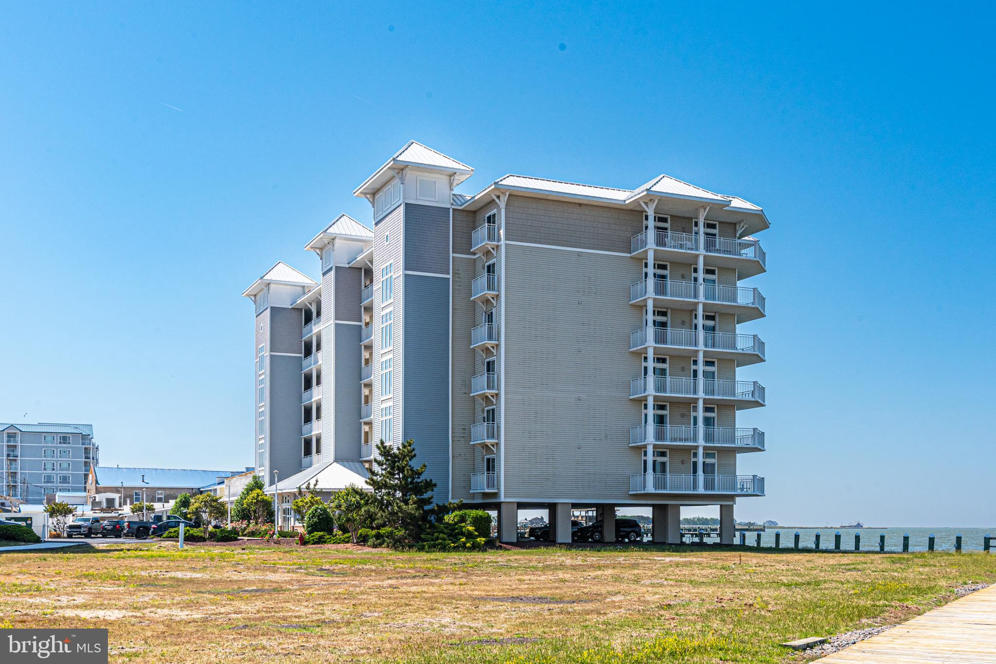 Perfectly positioned on a corner waterfront setting overlooking the Tangier Sound and Annemessex River, this beautiful corner condo offers breathtaking water views and unforgettable sunsets from the wraparound balcony, accessible through four sliding glass doors. The open-concept layout features a spacious living room, dining area, and kitchen accented by an electric fireplace, creating the perfect space for relaxing or entertaining. All four sliding doors are equipped with both interior plantation shutters and exterior hurricane shutters for added style and peace of mind.
The primary suite offers private access to a screened porch and features a luxurious bath complete with a walk-in shower, jetted tub, private water closet, and walk-in closet. Harbour Lights offers exceptional amenities including a waterfront pool, scenic boardwalk, and marina. A 30-foot boat slip is included, providing easy access to all the Chesapeake Bay has to offer. Condo fees include cable, internet, trash service, and more for added convenience.