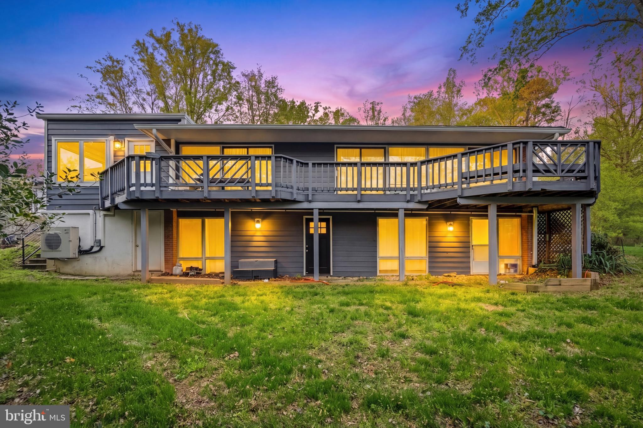 Tucked away on a quiet, tree-lined street just south of Potomac Village, this exceptional contemporary home offers a rare blend of privacy, character, and convenience. Surrounded by mature landscaping and peaceful wooded views, the property feels like a private retreat while remaining just minutes from shopping, dining, parks, and everyday amenities.

Filled with timeless mid-century modern vibes, the home is designed to bring the outdoors in. The dramatic main-level living and dining spaces feature soaring vaulted ceilings and an impressive wall of windows that frame the surrounding greenery and flood the home with natural light. Multiple sliding glass doors open to expansive decks and outdoor entertaining areas, creating a seamless connection between indoor and outdoor living. A striking slate fireplace serves as the focal point of the spacious living and dining areas, adding warmth and architectural character.

The heart of the home is the gourmet kitchen, featuring a large center island, quartz countertops, abundant cabinetry, a pantry cabinet, and a separate staging pantry with space for a second refrigerator. An additional breakfast nook provides a casual dining area and overlooks the beautiful natural surroundings.

A thoughtfully converted garage now serves as an expansive great room, complete with a mini-split system for year-round comfort, creating an ideal space for entertaining, relaxing, or gathering with family and friends. A side entrance provides convenient access to the private driveway with parking for multiple vehicles.

The main level also features a spacious primary suite with a large walk-in closet and an attached full bath, offering the convenience of main-level living. The fully finished walkout lower level expands the living space with a second family room, three additional bedrooms, two updated full bathrooms, ample storage, a laundry/workshop area, and direct access to the private backyard.

Outdoor living is equally impressive, with multiple decks, peaceful wooded views, and a dedicated vegetable garden, providing endless opportunities to enjoy nature and entertain outdoors.

Lovingly maintained and full of personality, this is far from a cookie-cutter home. Whether enjoyed as-is or reimagined to suit your vision, it presents a unique opportunity in one of Potomac's most desirable locations. Just moments from Potomac Village, Great Falls Park, Potomac Swim & Tennis Club, and top-rated schools, this special property offers an unmatched combination of privacy, lifestyle, and potential.