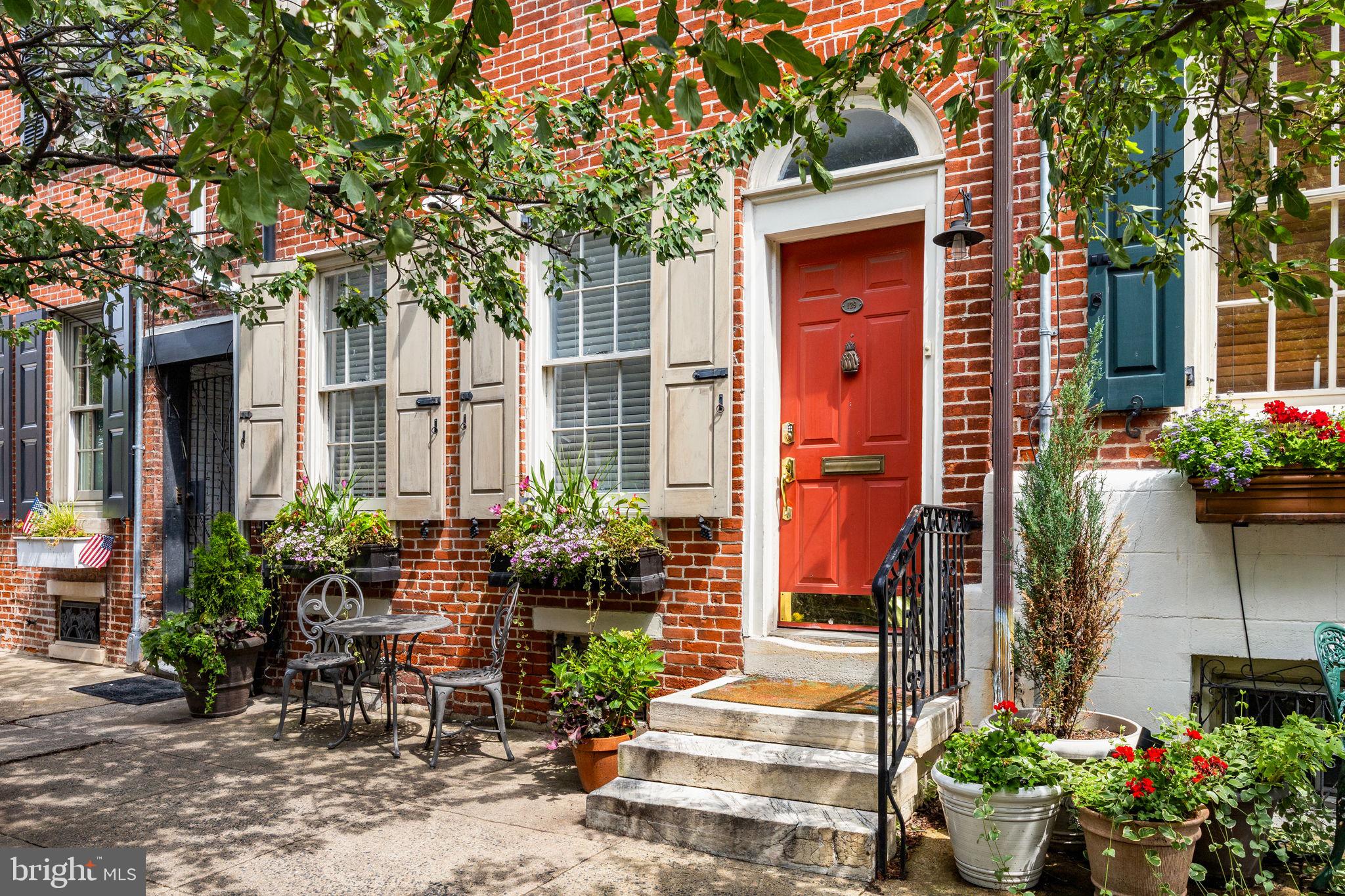 A rare opportunity to own a refined townhome with a fully separate, income-producing residence—tucked along a picturesque, tree-lined street in the heart of Queen Village.

129 Bainbridge pairs a sophisticated four-story main home with a charming trinity-style annex, accessed through its own private, gated entrance. The result is a seamless owner-occupant duplex: live beautifully while generating income that meaningfully offsets your monthly cost. With professional management already in place, the rental operates effortlessly.

The main residence offers thoughtfully designed living spaces, including a formal living room with fireplace and built-ins, an open kitchen and family room, and multiple bedroom suites across four levels. The top floor is dedicated to a serene primary suite with vaulted ceilings and a spa-like bath. A deck off the 3rd level offers a private outdoor respite.

A landscaped courtyard leads to the separate Trinity—complete with one bedroom, 1.5 bathrooms, and its own laundry—ideal as a turnkey rental, guest house, or private workspace.

Located within the Meredith Elementary School catchment.