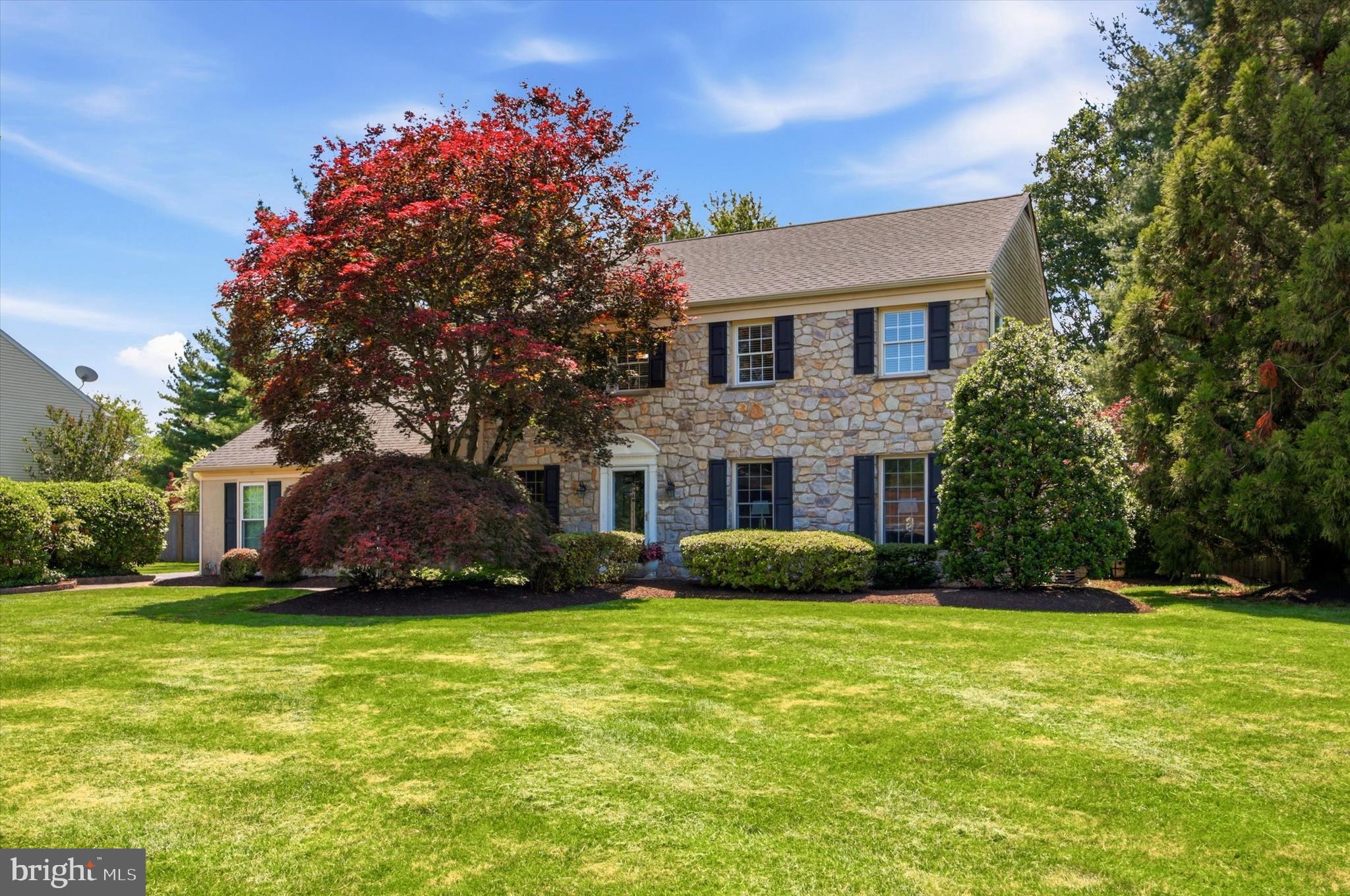 Welcome to this beautifully maintained stone-front Colonial in the highly desirable Robbins Park neighborhood of Upper Dublin Township. Set on a picturesque half-acre lot, this exceptional home offers the perfect blend of timeless elegance, modern updates, and outstanding outdoor living.
A charming paver walkway leads to the front entrance, where classic Colonial design and a traditional floor plan create a warm and inviting atmosphere. The spacious living room and formal dining room provide wonderful spaces for both everyday living and special gatherings. At the heart of the home is a beautifully appointed kitchen featuring abundant cabinetry, a stylish tile backsplash, stainless steel appliances, and a  center island that opens seamlessly to the expansive family room. Anchored by a cozy fireplace and surrounded by windows across the rear of the home, this inviting space is flooded with natural light and offers stunning views of the private backyard, truly bringing the outdoors inside. An updated powder room completes this level.
The finished lower level adds valuable living space with luxury vinyl tile flooring, creating the perfect setting for a home gym, recreation room, media area, or entertaining space. Also an unfinished space for laundry and plenty of storage.
Upstairs, you’ll find four generously sized bedrooms, including a spacious primary suite with a walk-in closet. Lovely dressing area leading to an updated ensuite bathroom featuring a stunning tile shower.  The beautifully updated hall bath showcases elegant cabinetry, quality finishes, and timeless style. Three additional bedrooms provide flexibility for family, guests, or a home office.
Step outside to your own private retreat, where a sparkling pool and hot tub, multiple  patios, mature landscaping, colorful gardens, and lush shrubbery create an idyllic setting for summer entertaining and peaceful relaxation. It doesn’t get much better than this.  Your very own private oasis. 
Long driveway leading to two car garage with access in to the house. Located within the award-winning Upper Dublin School District and close to parks, shopping, dining, and major commuting routes, this exceptional property offers the perfect combination of comfort, privacy, and location. A wonderful opportunity to call 205 Stout Road your new home.