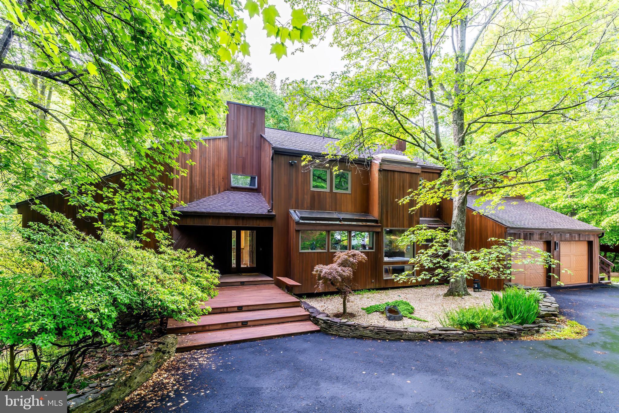 Join us this Friday, 5/23 from 5:30-7:30PM for an Open House! Welcome to 9700 Beach Mill Road—a rare opportunity to own an elegant and timeless contemporary designed by architect Richard Compton. This meticulously maintained 4 bedroom, 3.5 bath home is tucked away on a tranquil 2 acre lot and bordered by 10 acres of protected Virginia Land Trust and Resource Protected Area, offering privacy and serenity all while being just minutes from  the Great Falls Village Centre.

As you step inside, you're greeted by light-filled interiors and serene views of the surrounding landscape. Expansive windows throughout the home create a seamless connection to the outdoors, blending indoor comfort with natural beauty. Whether you're unwinding in a quiet moment or hosting guests, the well-designed layout offers the perfect balance of relaxation and functionality.

The two-story living room featuring a centerpiece fireplace is ideal for cozy evenings, while the formal dining room off the kitchen sets the stage for memorable dinners. The kitchen features stainless steel appliance, granite countertops, and stunning wooden built-ins. The large home office offers a built-in desk, ample storage, and expansive windows that frame beautiful natural views—an inspiring and peaceful setting for remote work or virtual meetings.

Upgrades throughout the home include gleaming hardwood floors, skylights, fresh paint, new carpet, updated lighting, and a stunning 2024 main-level addition—offering a full bedroom and bath perfect for guests, a second family room, or a rec space.

Upstairs, three spacious bedrooms include the primary suite with a spa-like en-suite bath, a generous walk-in closet, and a versatile bonus room ideal for a nursery, home office, or art studio. A conveniently located laundry room adds everyday ease.

Step outside to expansive decks designed for seamless outdoor entertaining, or soak in the beauty of the setting from the new side deck featuring a saltwater hot tub. Here, birdsong replaces background noise, and wildlife becomes your daily company.

The newly resealed two-car garage includes an electric vehicle charging station and ample storage space. Just off the garage you'll find the Generac 10kW backup generator and a wood shed.

Located in the highly coveted Langley High School pyramid and just minutes from Great Falls Village Centre, Tysons Corner, and the GW Parkway, this rare offering delivers the perfect blend of natural harmony, refined living, and accessibility.


Welcome home to your private sanctuary.