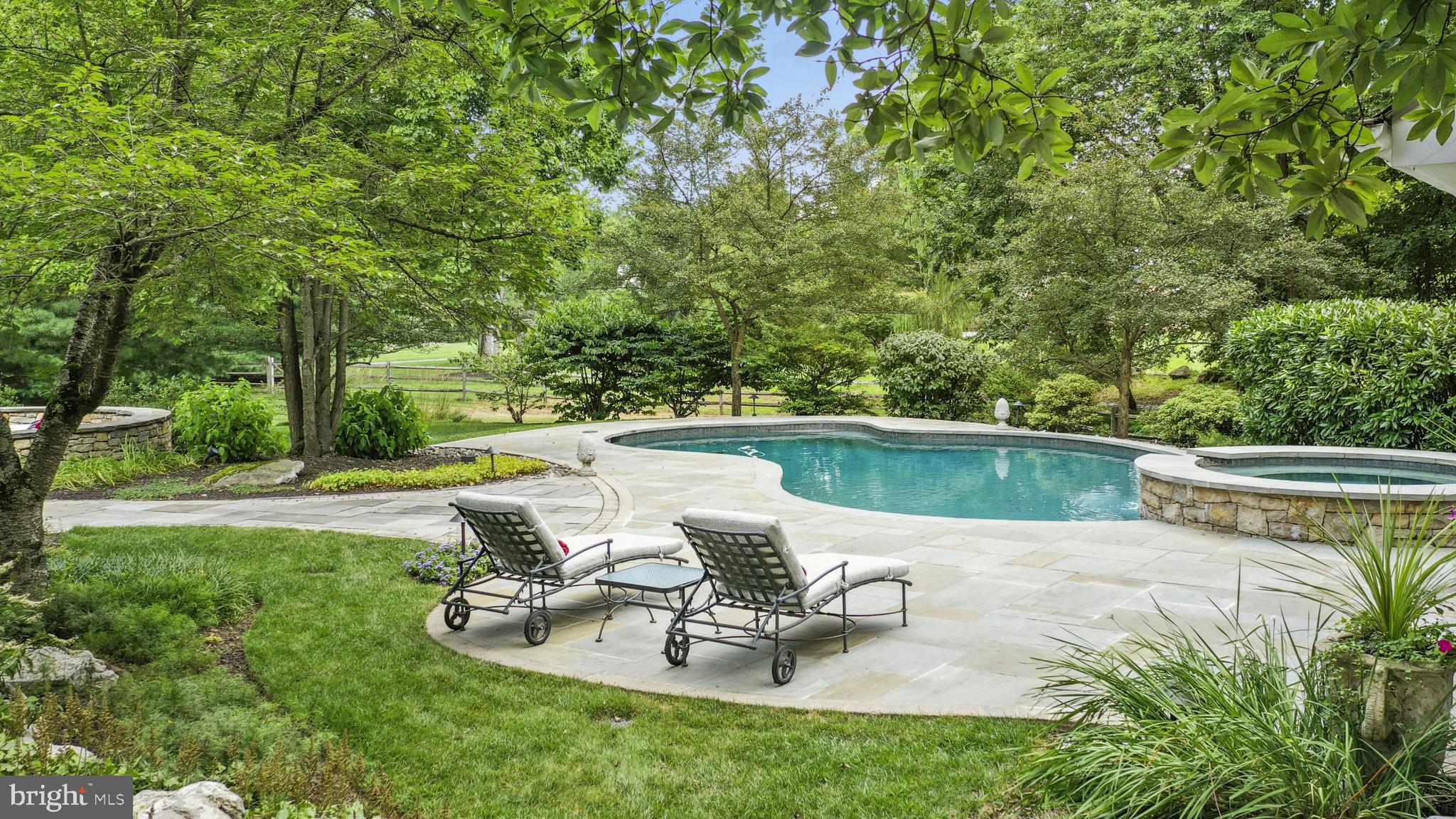 Welcoming… Restrained… Polite.  Fieldview has many of the qualities of a perfect host and is a particularly fine example of a Saucon Valley legacy property.  Here, the timeless design, with modern interpretations, provides exceptional livability. 
The original home was built in a time when quality was the rule and not the exception, while recent renovations and expansions have enhanced the original grace and charm, bringing this home up to today’s standards, with a nod to its rich history at every turn.  Fieldview is on a private cul-de-sac, off a quiet road, nestled in the center of 1.66 acres of specimen plantings and magnificent tall trees that only time and care can provide.
Inside, the amenities befit the house, where every room reveals delightful architectural details.  A house to live in and to cherish, attention to detail and care in craftsmanship is apparent throughout. The gracious foyer is flanked by an elegant dining room with a walk-in bay window and a handsome living room with fireplace, built-ins and adjacent wine room with wet bar. The family room, with fireplace and a wall of glass overlooking patio and pool, opens to the stunning kitchen, reimagined in 2023 and sure to delight all chefs. In addition, there is a first floor office with sitting room and full bath that could serve as a first floor bedroom suite, if desired.
There are three staircases to the second floor, privately accessing the four bedrooms. The primary suite has an exquisite bath with radiant-heated marble floors, marble shower with multiple shower heads and a luxurious soaking tub. The adjacent den with a fireplace beckons you to cozy up with a good book or watch your favorite movie. Two additional bedrooms and full baths are on a wing of their own while the East wing offers a separate bedroom suite for guests or a perfect teenager oasis.  
At day’s end, the family’s gathering place will most likely be the lower level with a game room for ping pong, shuffleboard or pool, and a 2nd family room with surround sound.  Adults will love the tasting room and wet bar.  A half bath completes this floor. For the car and hobby enthusiasts, the three-car garage will delight. 
The bucolic setting includes flowering gardens, a gentle waterfall, custom landscaping, backyard pool, pool house and patio areas offering extended venues for large gatherings.  Set amongst this screen of mature and specimen trees, the pool, spa and pool house flawlessly match the main residence.  This is a house to entertain in, to live in and to cherish, every bit as noteworthy as its location.  At once classic and elegant, while warm and comfortable, it is, indeed, the perfect family home.  This utterly romantic home may be the best property you will ever see, effortlessly striking a remarkable balance between spaciousness and warm intimacy.