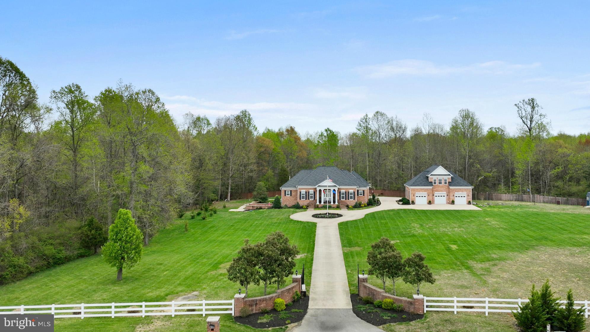 Experience the ultimate in privacy and elegance with this custom-designed estate, nestled on nearly 4 acres of serene land and accessed via a gated driveway. Boasting almost 7,000 sq ft of living space, this all-brick masterpiece offers the flexibility of up to 5 possible bedrooms and 3.5 bathrooms, designed with both comfort and style in mind.

As you enter, you’re welcomed by gleaming marble floors, soaring ceilings, and a spacious family room with a vaulted ceiling, hardwood floors, and a cozy wood-finished fireplace. Featuring extensive solid wood moldings and elegant chair rail detailing throughout, adding a timeless touch of craftsmanship and character to the interior spaces.  The custom kitchen is a chef’s dream, featuring tall cabinetry, striking granite countertops, and an oversized island perfect for entertaining.

Main level, you'll find three generously sized bedrooms, including a Jack & Jill bath with a ceramic-tiled walk-in shower. The luxurious owners  suite offers a vaulted ceiling, a large walk-in shower, and a custom walk-in closet with built-in shelving.

The lower level is an entertainer’s paradise, accessed by stunning custom cherry hardwood stairs and landing. Highlights include an expansive custom-built bar with rich cabinetry and sleek granite, newly stained concrete flooring, a dedicated theater room with a large projector and surround sound, a newly renovated bathroom with a walk-in rain shower, and two additional spacious rooms currently used as bedrooms.

Double doors open to a beautifully landscaped courtyard, allowing natural light to flood the lower level. The home is fully equipped with whole-house surround sound wiring, two laundry rooms (one on each level), and a custom wine room complete with a hidden safe room—perfect for wine enthusiasts and collectors.

Additional features include:

2-car attached garage with custom cabinetry and storage
3-car detached garage converted into a “man cave” with a finished upper-level office and its own HVAC system—ideal for an in-law suite conversion
A composite deck with vinyl fencing overlooking a private heated gunite pool recently converted to saltwater, complete with new cover and skimmer
Updated tiki bar and newly installed hot tub with cover
This home also comes with a host of recent upgrades:

Lifetime warranty CertainTeed Carriage House designer shingles
New concrete pads and sidewalks, garage door, window screens, and shutters
New appliances, septic pump, and updated electrical system
Prepped for a tankless water heater (with completed plumbing and electrical)
Permit filed for egress window in the lower level bedroom
Irrigation system installed around the landscaped grounds
All utility poles removed for a cleaner aesthetic
Custom flag pole added
No HOA and home warranty included
This exceptional estate blends high-end design, comfort, and functionality—all in a peaceful Southern Maryland setting. A truly unique opportunity for luxurious estate living.