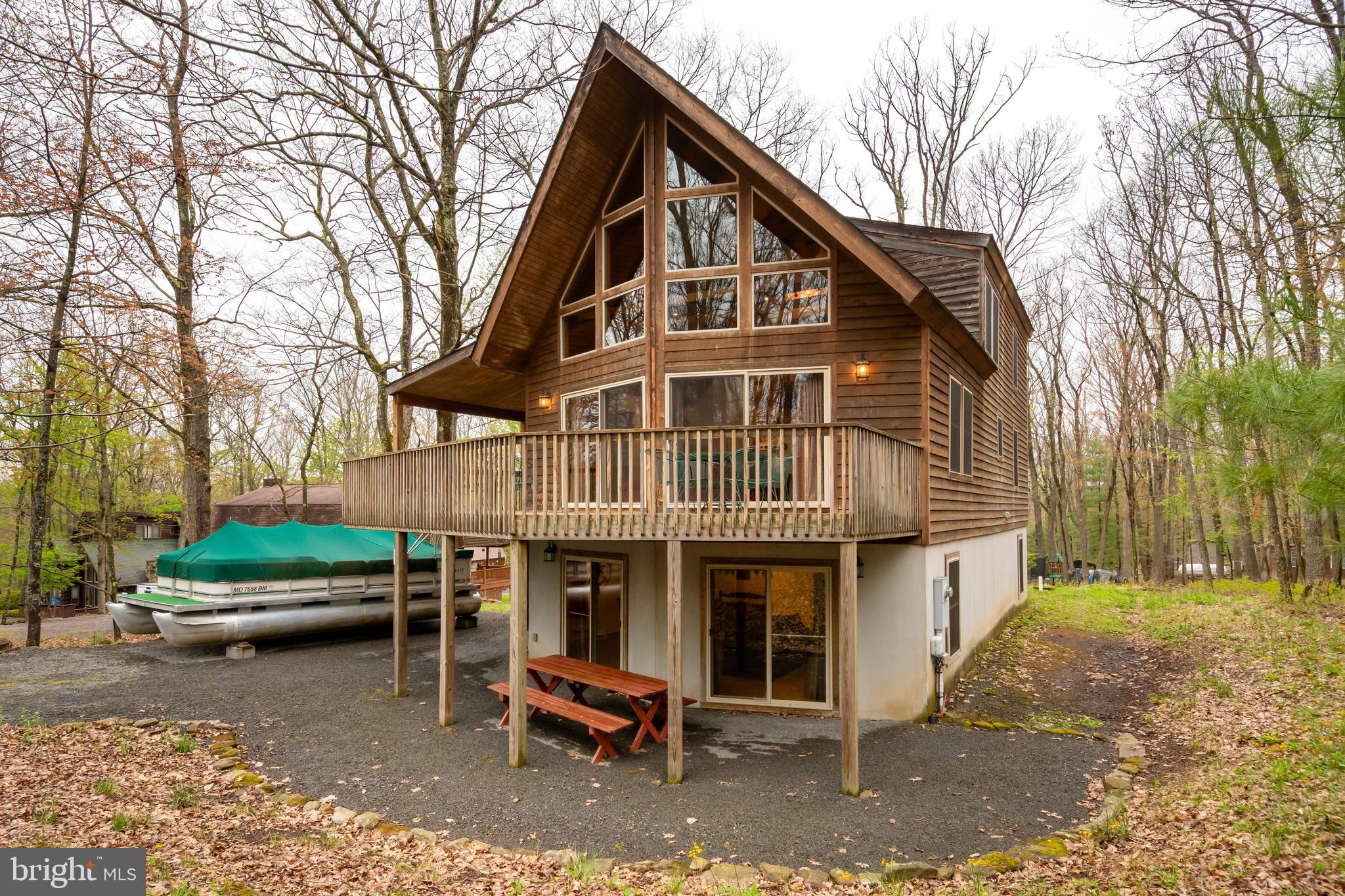 Tucked away in the peaceful, lake access community of Sky Valley, you’ll find this inviting chalet that offers the perfect blend of privacy and recreation. With five bedrooms, an open floor plan, cathedral/beamed ceilings, two family rooms, and three levels of living space, there’s plenty of room for everyone. Stay warm on chilly winter evenings with the stone wood burning fireplace in the living room and walk right out to grill dinners on the deck or covered porch via one of the sliding doors in the LR/DR area. Enjoy the added bonus of a potential dock slip, making it easy to take advantage of nearby water activities. The Sky Valley community amenities include an expansive lakefront area, private beach with swim platform, playground, community docks, boat launch ramp, community fishing pond, and picnic areas. Use your golf cart or ATV for quick access to the waterfront area. Surrounded by natural beauty, this property offers the perfect balance of privacy and accessibility, making it an excellent base for enjoying lake life, outdoor adventures, or quiet evenings at home.