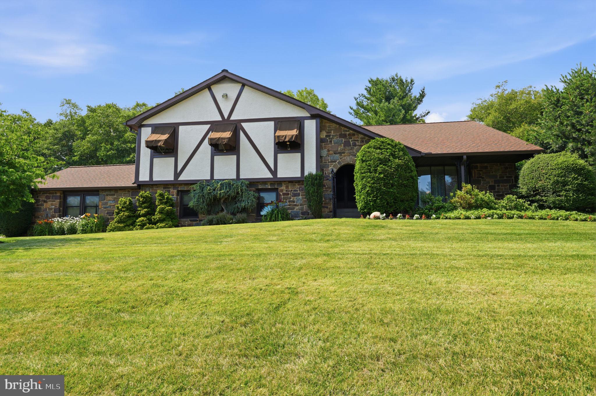 Ideally situated in the desirable Justa Farms East section of the Albidale neighborhood in Huntingdon Valley, this exceptional Tudor-style, split-level residence with striking stone façade, is in the award-winning Lower Moreland Township School District. Combining timeless architecture with quality craftsmanship, spacious living areas, and outstanding indoor and outdoor amenities, this beautifully maintained home offers an exceptional lifestyle.
A covered front entrance with elegant double doors opens to a spacious foyer leading to an inviting living room featuring hardwood flooring, recessed lighting, bay window, and a decorative mirrored accent wall. The formal dining room features French doors that open to the expansive rear deck, creating the perfect setting for indoor and outdoor entertaining.
The beautifully appointed kitchen is designed for both everyday living and entertaining, featuring granite countertops, ceramic tile flooring, recessed lighting, tiled backsplash, double Dacor oven and Dacor range, spacious 48-inch Sub-Zero refrigerator, and an abundance of custom cabinetry and countertop space. The bright sun-filled kitchen boasts a large seating area with built-in bench seating, a bay window, skylights, and direct access to the backyard patio.
The master bedroom includes a walk-in closet with custom built-ins, and a luxurious bathroom complete with heated floor, oversized shower with bench seating, a soaking tub, and premium finishes. Two additional bedrooms are generously sized with ample closet space and are served by an updated hall bathroom with double vanity. Up a few steps from the hallway is a spacious fourth bedroom with two closets.
The downstairs level features a private home office, an oversized laundry room, and a conveniently located powder room. The impressive and captivating family room is highlighted by a dramatic floor-to-ceiling stone façade, gas fireplace, custom full-wall entertainment built-in, and sliding glass doors leading to a side patio with awning.
The finished basement offers flexible space that is ideal for a recreation room, fitness area, playroom, or media room, along with abundant storage.
The professionally landscaped grounds create a private backyard retreat featuring a heated in-ground swimming pool with a 9-foot-deep end, expansive patio for entertaining and sunbathing, pergola, tranquil pond, mature landscaping with stunning perennials and lush greenery, manicured lawn, and storage shed with electricity. Custom awnings provide additional comfort and energy efficiency throughout the home.
Significant features include a new gas furnace (2021), new water heater (2026), replaced roof, gutters, and windows (2014), new gas fireplace (2026), new garage door opener (2026), four-zone hot water baseboard heating, two-zone central air conditioning, and sound system in many rooms of the residence.
The home is perfectly located on a quiet street, around the corner and just a short walk to Lower Moreland Park which offers abundant outdoor recreation choices, such as a playground, a scenic walking path, athletic fields, tennis courts, a basketball court, and a neighborhood pond. Also, close by is the popular Pennypack Trail. 
The home is served by the Blue Ribbon Lower Moreland Township School District, consistently ranked among Pennsylvania's top public school districts, and recognized for its academic excellence, college preparation, outstanding teachers, and strong extracurricular programs. Shopping centers, fitness centers, coffee shops, grocery stores, and a wide selection of restaurants are just minutes away.  There is convenient access to Routes 1, 232, and 63; the Pennsylvania Turnpike; I-95; and the West Trenton Regional Rail Line. 
The combination of top-rated schools, a beautiful neighborhood, and everyday conveniences will certainly add to the pleasure of living in this amazing home with its striking features and picture-perfect location.