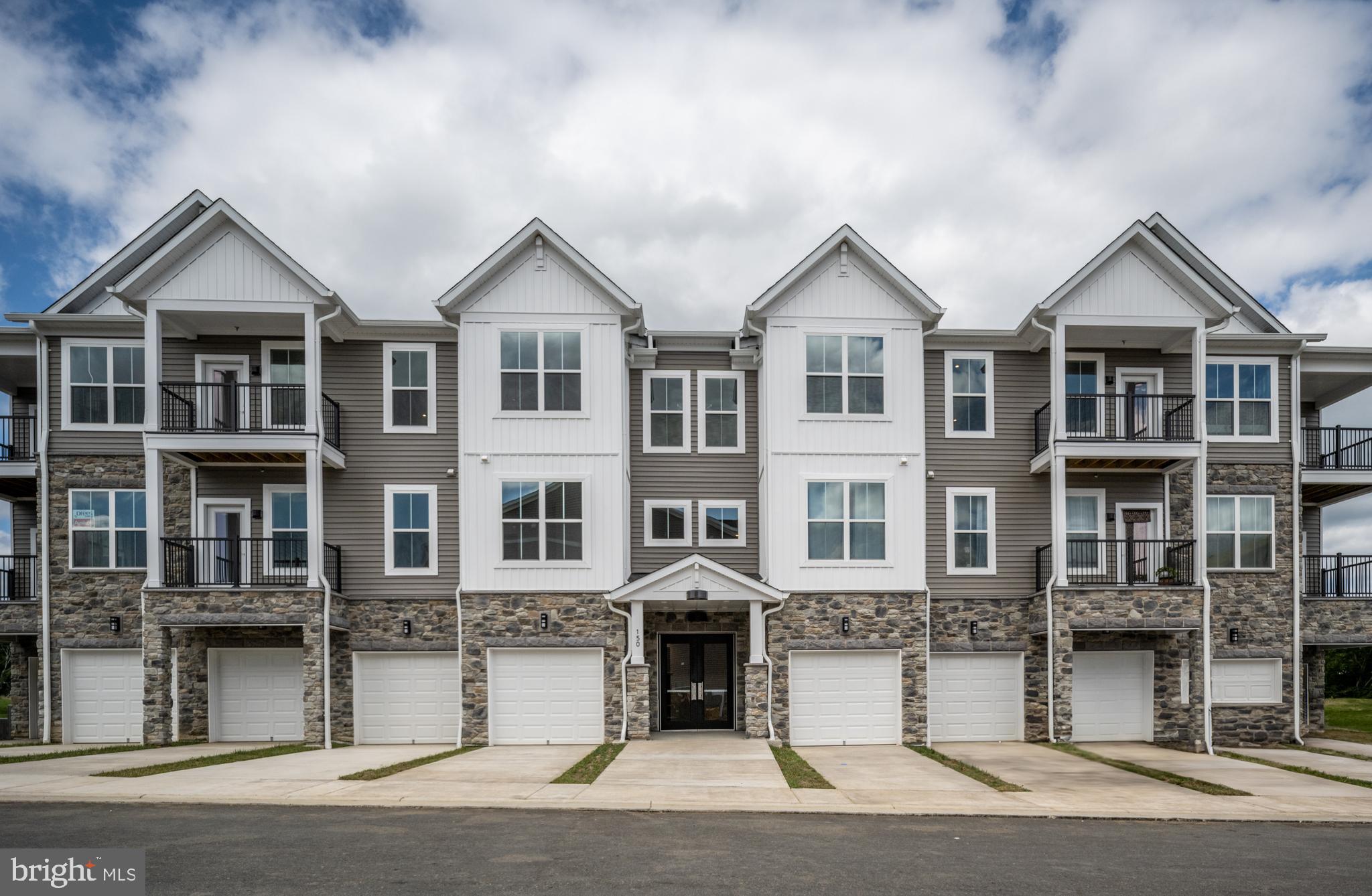 Welcome to this stunning new 2 bedroom, one-level condo located in the highly sought-after Embrey Mill community, designed for luxury and comfort. This secure, low-maintenance building features stone accents, private garages with driveways, and spacious balconies, offering both style and convenience. Step inside through a covered front entrance into a magnificent two-story atrium foyer with a furnished design and elevator access to one-level homes. Each residence offers private, individual entries, smart video intercom access, and included garage door openers with remotes. Enjoy the added benefits of a well-lit, private storage area, a staircase for alternate entry, and fire suppression for peace of mind.

Inside, a spacious foyer with tray ceiling detail and a convenient coat closet leads to a vast open-concept living space. The informal dining area and large kitchen, complete with a generous island large enough for four stools, flow into the family room with soaring ceilings and an abundance of natural light. Off the family room is just one of the airy balconies to utilize. The gourmet kitchen is a chef's dream with upgraded quartz countertops, stainless steel Whirlpool appliances, including a 5-burner electric range with an air fryer upgrade, full-sized microwave, French door refrigerator, and luxury dishwasher. The pantry is oversized, and additional kitchen space is perfect for a coffee bar or butler’s pantry. A designer ceramic tile backsplash, pull-out shelves in lower cabinets, and 42-inch upper cabinets with modern finishes complete the space.

The oversized primary suite is a retreat of its own, with an impressive walk-in closet and large windows providing natural light. A private, spacious balcony off the primary bedroom includes a hose bib for all your gardening needs The adjoining primary bath features a double vanity, upgraded long vanity with six drawers for ample storage, a super shower with ceramic tile from floor to ceiling, and a frameless glass enclosure. An additional spacious secondary bedroom with walk-in closet is perfect for guests, home office, or quiet retreat. Throughout the home, you'll find luxury vinyl plank flooring, plenty of downlighting, pre-wires for ceiling fans, and a pocket office with quartz countertops and cabinetry. Added conveniences include a large laundry room with rough-in for a sink and ample storage. Energy-efficient features, including right-sized HVAC, programmable thermostat, and smart technology, ensure this home is both comfortable and sustainable.

Embrey Mill's location is unbeatable—just minutes from I-95 and Route 1, between two bustling shopping hubs, including Garrisonville Road and Embrey Mill Town Center. Enjoy nearby access to the newest Publix grocery store and more. The community offers top-tier amenities, including an exclusive clubhouse for active adult residents, featuring a kitchen, game room, private fitness center, yoga room, and on-site activities director. Relax outdoors with multiple fire pits, patio seating, outdoor gas grills, and even giant chess. For those looking to stay active, enjoy private pickleball and bocce courts, ensuring there's always something to do right outside your door.