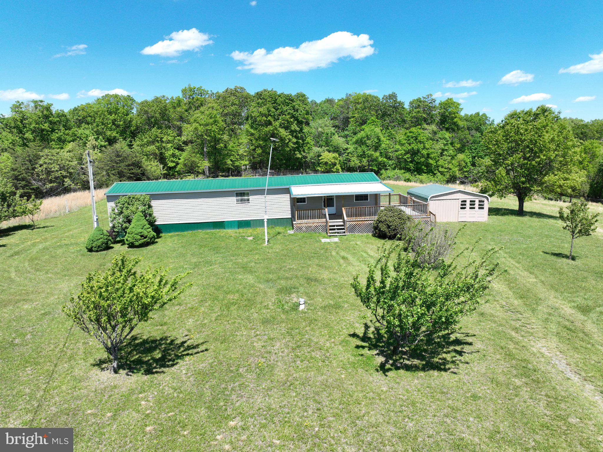 Nestled in the serene Shanks WV, this charming manufactured home offers a unique blend of comfort and tranquility on a sprawling 5-acre lot. With 2  bedrooms and 1.5 bathrooms.   A new large deck allows you to take in the gorgeous sunrises and sunsets as the views are abundant. The exterior, adorned with durable vinyl siding, complements the picturesque surroundings, while the expansive lot provides endless possibilities for outdoor activities or serene retreats. Enjoy the convenience of a private driveway, ensuring easy access to your personal oasis. The interior is your blank slate to step in and make it your own. Embrace a lifestyle of peace and privacy, where nature meets comfort, and create lasting memories in this inviting space.  

New subfloor has been installed, plumbing replaced, new kitchen electrical wiring, replaced heat venting, replace electrical box, replaced furnace, and insulated under the trailer.  Metal roof installed 2017.