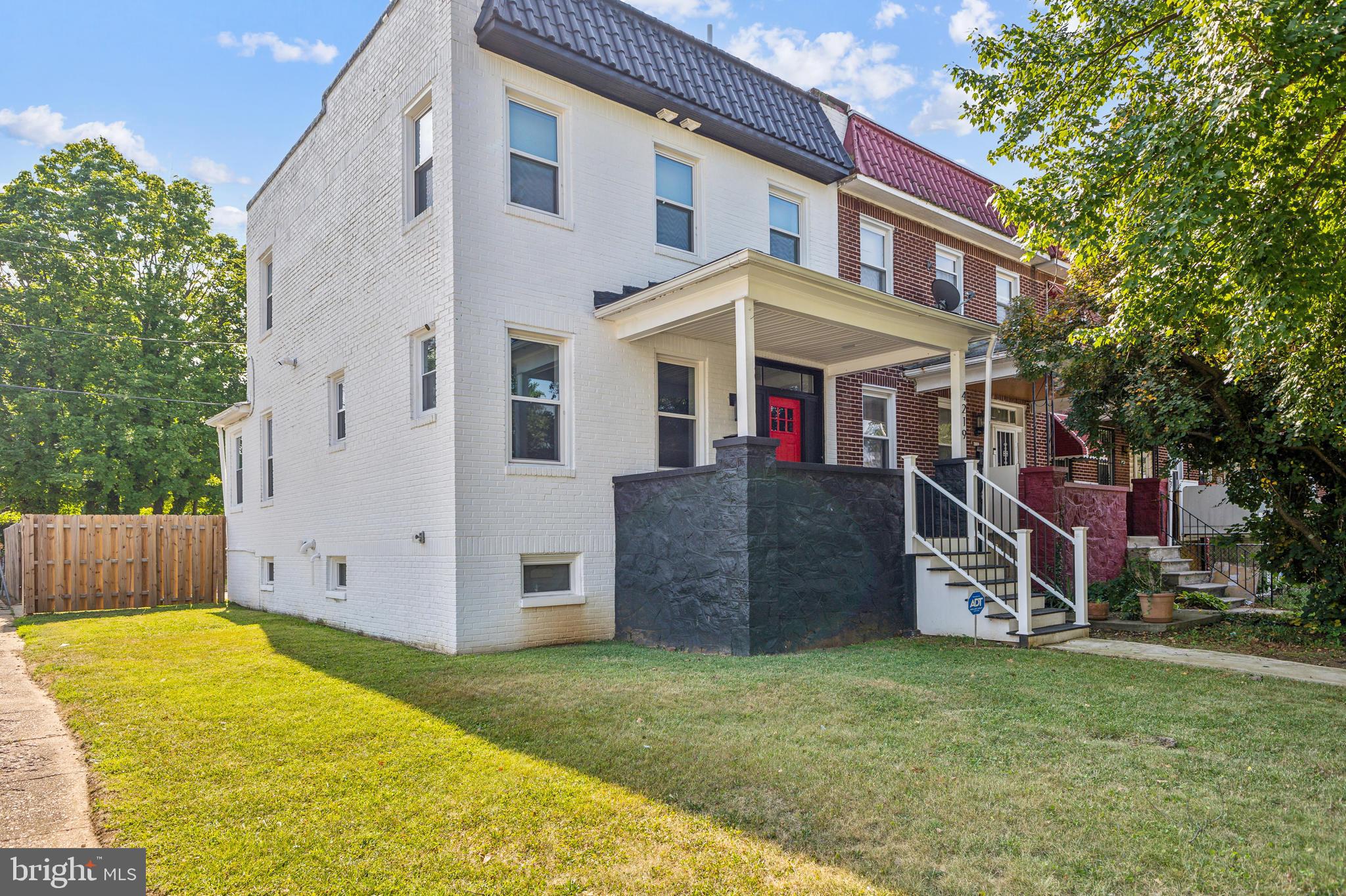 Welcome to this stunning, fully renovated end-unit townhouse, where modern luxury meets timeless charm. Spanning three finished levels, this beautifully upgraded home offers an ideal blend of elegance, space, and functionality—perfect for families or individuals alike.

Upstairs, you'll find three generously sized bedrooms and two full bathrooms, including a serene primary suite with a spacious walk-in closet and a private en-suite bath. The secondary bedrooms are styled in a soft gray palette with crisp white trim, creating a bright and airy ambiance that suits a variety of needs.

The heart of the home is the modern kitchen, showcasing sleek white cabinetry, a bold black hexagonal tile backsplash, and elegant globe pendant lighting over a white marble countertop that doubles as a breakfast bar. An adjacent open-concept dining and living area is bathed in natural light from large windows and features stylish gray wood-look flooring throughout.

Outside, the home's striking white facade is accented by a contrasting black wall and a vibrant red front door, enhancing both curb appeal and character. The neatly landscaped yard is enclosed by a wooden privacy fence along the side, adding to the home's inviting and secure feel.

The finished basement offers a cozy and flexible space—ideal for a media room, guest suite, or home office—and includes a full bathroom, as well as an energy-efficient washer and dryer. Step out back to a fenced-in yard with a small staircase and practical space for outdoor enjoyment or private parking.

Additional highlights include a newer HVAC system installed in 2022, ensuring year-round comfort.

Don’t miss the opportunity to make this beautifully updated home your own!