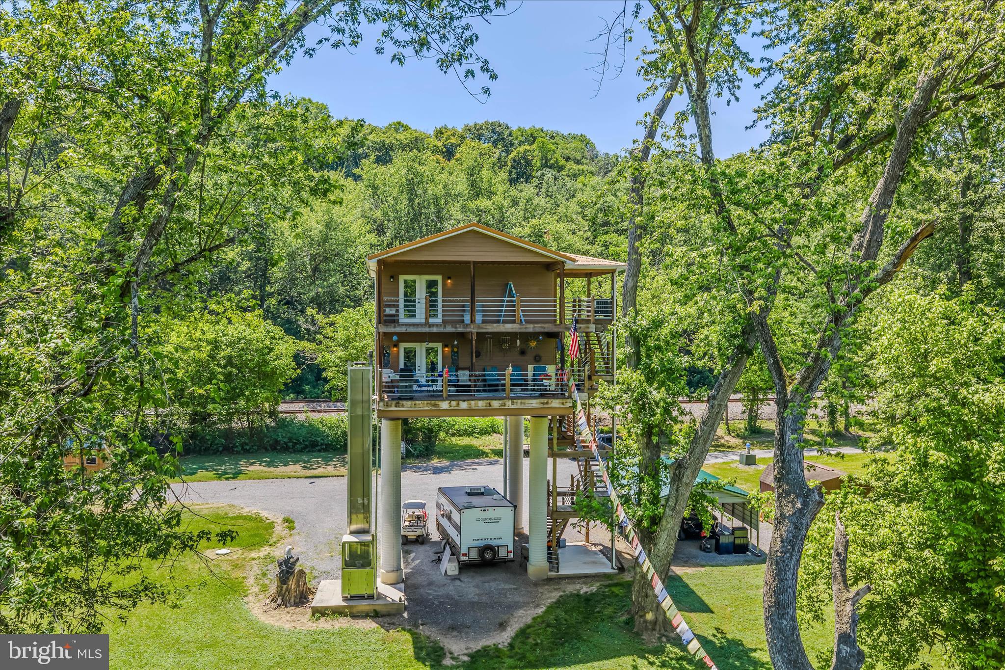 Enjoy breathtaking river views from your own treetop retreat. This charming home features 2 bedrooms and a stylish bathroom accented with Italian-imported tiles. The kitchen boasts countertops adorned with tiles from Mexico, and flows seamlessly into the open dining and living areas with wood floors, all leading to a deck overlooking the river. Upstairs, both bedrooms and the bath open to another deck with stunning views. Stroll along the river to your private beach, with a state-owned island ensuring your view remains unobstructed. Built on sturdy concrete pillars to meet engineering standards, it’s designed to withstand potential flooding, and elevator adds extra convenience for grocery days. With no restrictions, make it your full-time treetop paradise or a short-term rental getaway.