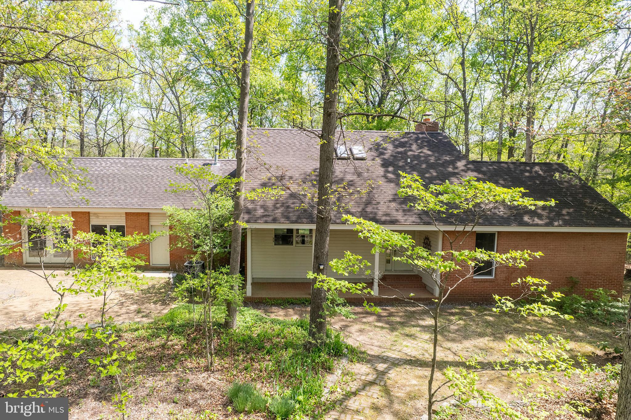 Spacious custom contemporary home set on 8.89 scenic acres, offering peaceful rural living just minutes from Winchester with convenient access to commuter routes. Designed and built by the original owner/architect, this property features 9+ ft ceilings with exposed wood beams, blending character and craftsmanship throughout.

This 4-bedroom, 3-bath brick home offers wood and tile flooring throughout, a cozy living room with a wood-burning fireplace and forced air insert, and a spacious kitchen with ceramic tile countertops and ample workspace. The main level includes a primary suite with a jetted tub and separate shower, along with a guest bedroom for added convenience.

Enjoy the outdoors from the covered front and rear porches or relax on the brick patio overlooking the surrounding acreage. Additional features include two water heaters, an owned 500-gallon underground propane tank, and septic pumped in 2025. High-speed internet is available.

Seller is in the process of dividing the land and establishing an easement—see attached plat for details. Seller will also replace roof with acceptable offer. Septic system is designed for <#BR.