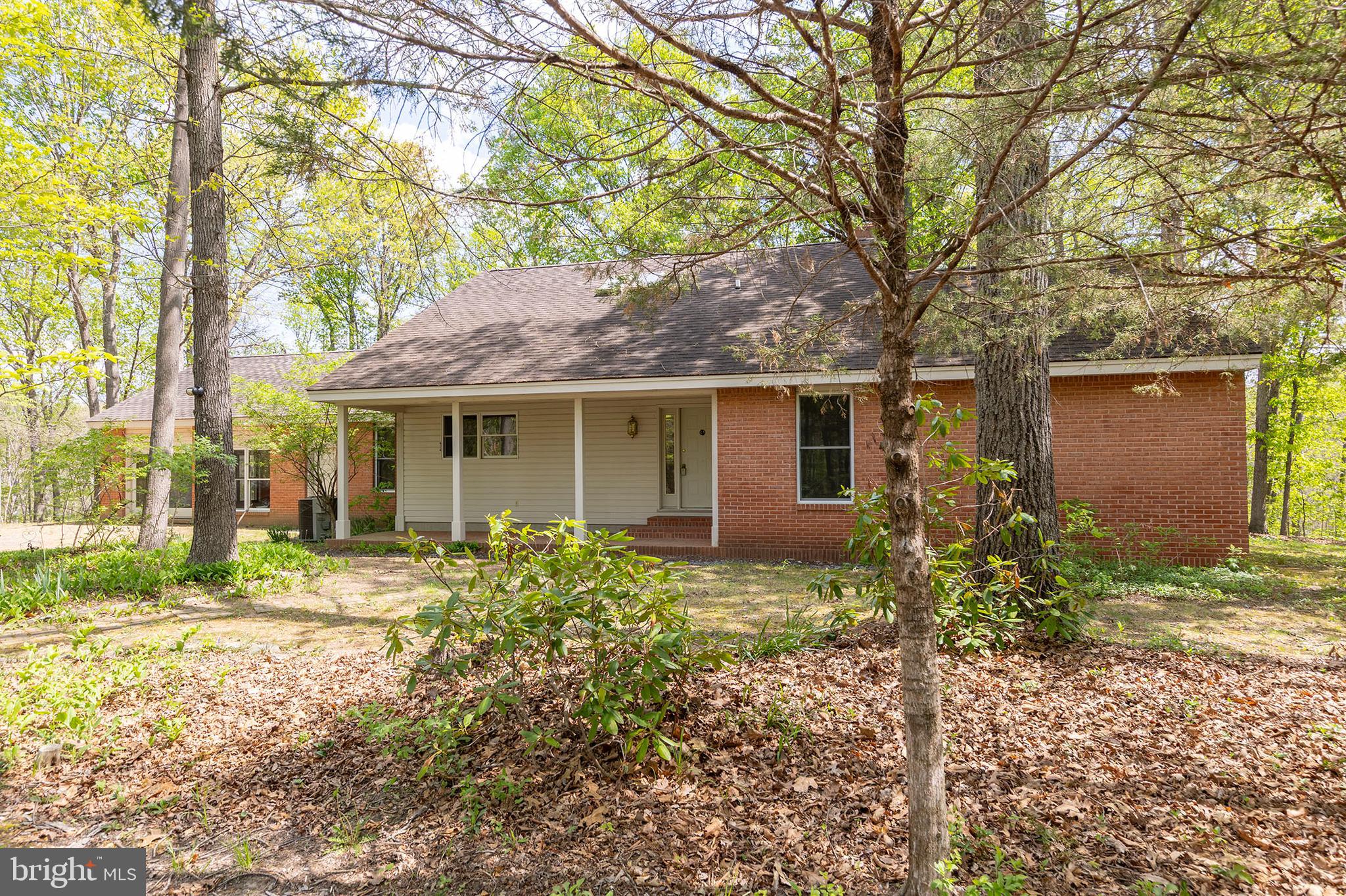 Spacious custom contemporary home set on 8.89 scenic acres, offering peaceful rural living just minutes from Winchester with convenient access to commuter routes. Designed and built by the original owner/architect, this property features 9+ ft ceilings with exposed wood beams, blending character and craftsmanship throughout.

This 4-bedroom, 3-bath brick home offers wood and tile flooring throughout, a cozy living room with a wood-burning fireplace and forced air insert, and a spacious kitchen with ceramic tile countertops and ample workspace. The main level includes a primary suite with a jetted tub and separate shower, along with a guest bedroom for added convenience.

Enjoy the outdoors from the covered front and rear porches or relax on the brick patio overlooking the surrounding acreage. Additional features include two water heaters, an owned 500-gallon underground propane tank, and septic pumped in 2025. High-speed internet is available.

Seller is in the process of dividing the land and establishing an easement—see attached plat for details. Seller will also replace roof with acceptable offer. Septic system is designed for <#BR.