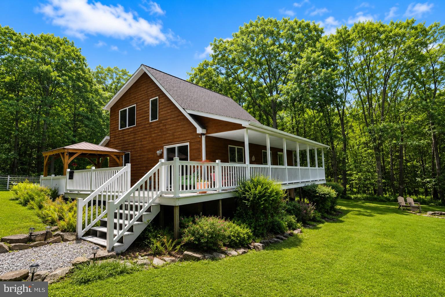 Assumable VA loan at a below-market interest rate may be available...contact listing agent for details. If peace and privacy are on your must-have list, this one delivers! Picture this: you pull into the driveway and the trees close in around you on three sides, like the forest itself is standing guard. Over an acre of land, and somehow it stays flat and usable instead of the steep, awkward terrain so common in this area. This is a lot you can actually walk, garden, and live on.

Step onto the front porch and you'll understand why past owners rarely wanted to come inside. The view stretches out far enough to make your coffee cup last a little longer every morning. In the evenings, the saltwater hot tub (just a few years young) turns this into the kind of backyard people usually only dream about.

Inside, the kitchen and main-level bathroom were recently remodeled with an eye for quality over trend, so you get the updates without the "flip house" feel. The ensuite bedroom on the main level is a fantastic one-level living option.

Out back, a garage-sized shed and a separate potting shed give you room for tools, toys, or a hobby waiting to happen, and there's a garden plot already established for whoever's ready to put in the work.

This isn't a house that's trying to impress you with size. It's a property that's already figured out what matters: privacy, usability, upgrades that make daily life easier. Come see why the setting sells itself.
