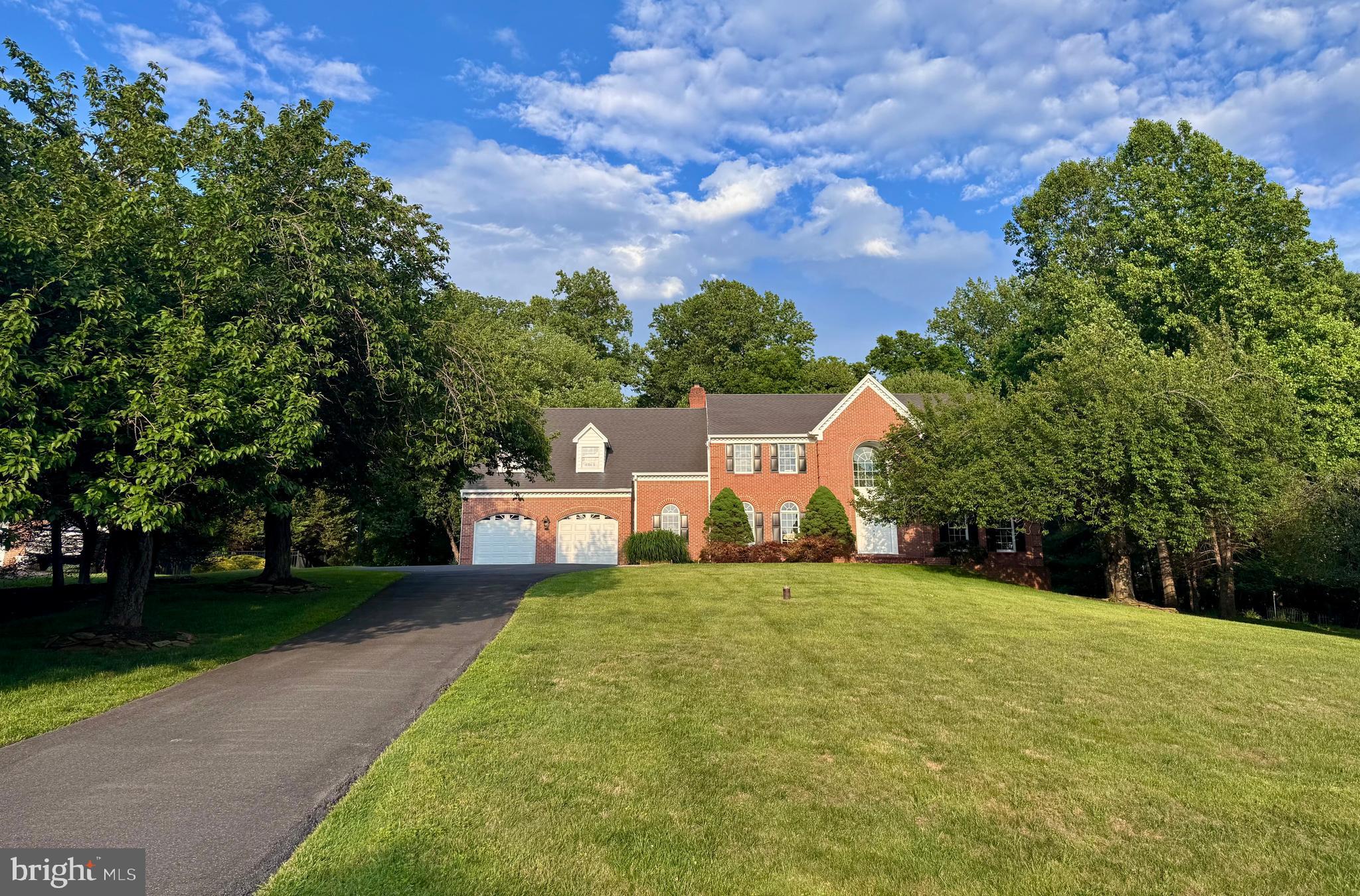 *** Priced to Sell ! *** Seeking the tranquility of an open nature retreat while still being part of a welcoming neighborhood, with easy access to the conveniences of modern city life? Welcome to 18117 Hayloft Drive, a stunning three-sided brick-front colonial estate by Murphy Brothers, set on a picturesque 1.36-acre lot in prestigious Granby Woods. Backing to woods and open land, this private retreat offers breathtaking natural scenery, peaceful sunrise views, and exceptional outdoor living with an expansive deck, elegant arched bridge, and charming Japanese-style gazebo overlooking a scenic backyard oasis.
Inside, sun-filled living spaces and soaring ceilings create a bright, open, and airy atmosphere throughout. The grand entrance showcases imported marble flooring and high-end Austrian Strassburg chandeliers, adding timeless elegance and luxury. The home features five spacious upper-level bedrooms, three full baths, two powder rooms, a formal library, a finished walk-out basement, and space for a potential future main-level bedroom suite.
*** MAIN LEVEL:
Grand two-story foyer with imported marble flooring, a Palladian window, and an Austrian Strassburg chandelier. Elegant library with custom built-ins. Sun-filled living and dining rooms with hardwood flooring and scenic nature views. Dramatic two-story family room with 18-foot ceilings, a soaring floor-to-ceiling stone fireplace, oversized Palladian window, and French doors leading to the expansive deck. The bright gourmet kitchen features quartz countertops, a large island with a Jenn-Air cooktop, new stainless steel appliances, and a breakfast area overlooking the backyard oasis. Numerous windows and a French door provide additional deck access. A flexible den offers the potential for a main-level bedroom suite. The large laundry room includes ceiling-height cabinetry, a utility sink, and a second powder room with a third direct deck access point. The oversized garage offers ample storage.
*** UPPER LEVEL:
The spacious primary suite features serene nature views, two walk-in closets, and an additional attic storage closet. An adjoining sitting room is ideal as a study, nursery, or fifth bedroom. The luxurious primary bath includes a whirlpool tub beneath a Palladian window. All bedrooms offer spacious closets, abundant natural light, and beautiful views of the surrounding landscape.
*** LOWER LEVEL:
Finished walk-out basement with a large recreation room, wet bar, full bath, recessed lighting, and an expansive unfinished area for storage or future customization.
*** UPDATES:
2026 – New carpet throughout; new kitchen countertops and backsplash; new kitchen appliances; new flooring in the laundry room and powder room; new rear French patio door: new shower door in master bath room. 
2025 – Front door and arched entry upgraded with maintenance-free exterior finishes; new washing machine; fresh paint throughout nearly all living areas.
2023 – New hot water heater; new driveway.
2022 – New garage doors; new hardwood flooring in the sitting room.