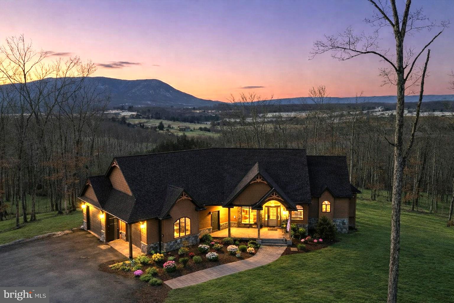 Panoramic mountain views stretching for miles define this custom-built estate, priced UNDER recent appraised value. Designed to capture views from nearly every window, the home pairs refined craftsmanship with the natural beauty of the Shenandoah Valley, framed by the Blue Ridge Mountains, Signal Knob, and the Appalachian Mountains.

The property consists of two separately recorded 10-acre parcels, totaling 20 private acres. The primary parcel includes the main residence, detached guest house, lake frontage, pool, and outdoor living areas. The second 10-acre parcel offers additional building potential, featuring a 4-bedroom perk and the ability to construct another primary dwelling plus up to two additional dwellings—ideal for a family compound, multi-generational living, Airbnb use, future expansion, or long-term investment. Zoning permits livestock, allowing for a rural lifestyle without sacrificing estate-level design.

The main home is positioned to maximize views, with expansive windows overlooking rolling ridgelines. A stacked stone double-sided fireplace anchors the living space. The gourmet kitchen features high-end appliances, premium finishes, and a large picture window with mountain views. The owner’s suite offers private porch access and a spa-style bath with heated floors. The finished basement includes 9-foot ceilings and a custom staircase that enhances the home’s architectural presence.

Outdoor living is a centerpiece of the property. An 8x12 multi-slide door opens (disappearing into the wall) to a large covered Trex deck with a stone wood-burning fireplace. A pool and private hot tub overlook the mountains, creating a true resort-style setting.

Practical features include an oversized attached 2-car garage, generator hookup, full RV hookup with electric and clean-out, and a powered storage shed.

The detached guest house features a 1-bedroom, 1-bath layout with a gourmet kitchen, clawfoot soaking tub, walk-in shower, custom closet, and jacuzzi hookup—ideal for guests, extended family, a private retreat, or income potential.

The land supports abundant wildlife and recreational opportunities, including fishing, kayaking, and a designated outdoor target shooting area. Located within Lake John Estates, the community offers private lake access and exclusive access to the North Fork of the Shenandoah River.

Luxury, land, waterfront, and long-term flexibility—combined into one rare estate offering.