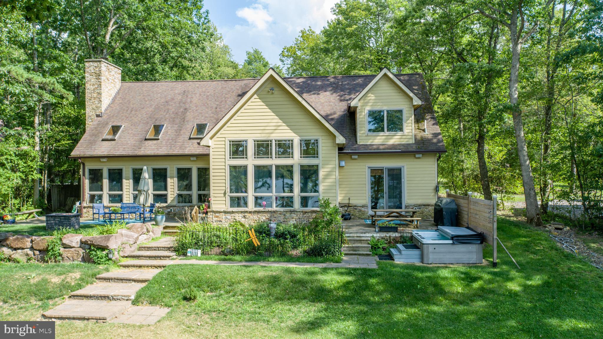 Amazing lakefront home with expansive views of Deep Creek and 122 feet of premium, level lakefront and a private Type A boat dock! Incredible living room with a wall of windows overlooking the lake and a vaulted ceiling, custom wood floors, and an oversized stone fireplace. The upscale, gourmet kitchen features stainless steel appliances and floor to ceiling windows along the lakeside dining area that bring in natural light and breathtaking water views.  The spacious master suite has a sitting area, widow seat facing the lake, and private bath with double vanity sink and steam shower with pebble ceramic tile flooring. The upstairs rec room is also the 4th bedroom/bunk room that is perfect for games and hosting family and friends.  The exterior features a lakeside deck/porch with hot tub and fire pit near the shoreline to create those special memories. Also featuring a 2 car attached garage and radiant floor heat. Don't miss this  opportunity to buy a great house on a great lakefront lot!