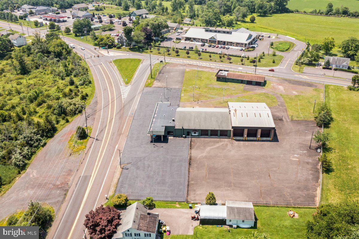 Highly visible commercial property situated at the signalized intersection of Route 611 and Route 412 in Ottsville, Nockamixon Township, Bucks County. This 12,000 square foot facility sits on 2.38 acres with over 400 feet of combined road frontage and 50+ parking spaces. The property features three 14-foot drive-through garage bays, over 2,000 square feet of office and showroom space, and is fully fenced with existing signage in place. Renovated in 2023 with Phase 2 environmental complete and satisfactory. Property is zoned Village Center (VC) with a conditional use approval in place — buyers and their counsel should independently verify permitted uses with Nockamixon Township prior to making an offer. An excellent opportunity for owner-operators or investors seeking a well-positioned, infrastructure-rich property at one of upper Bucks County's most traveled intersections. Priced at $2,300,000.