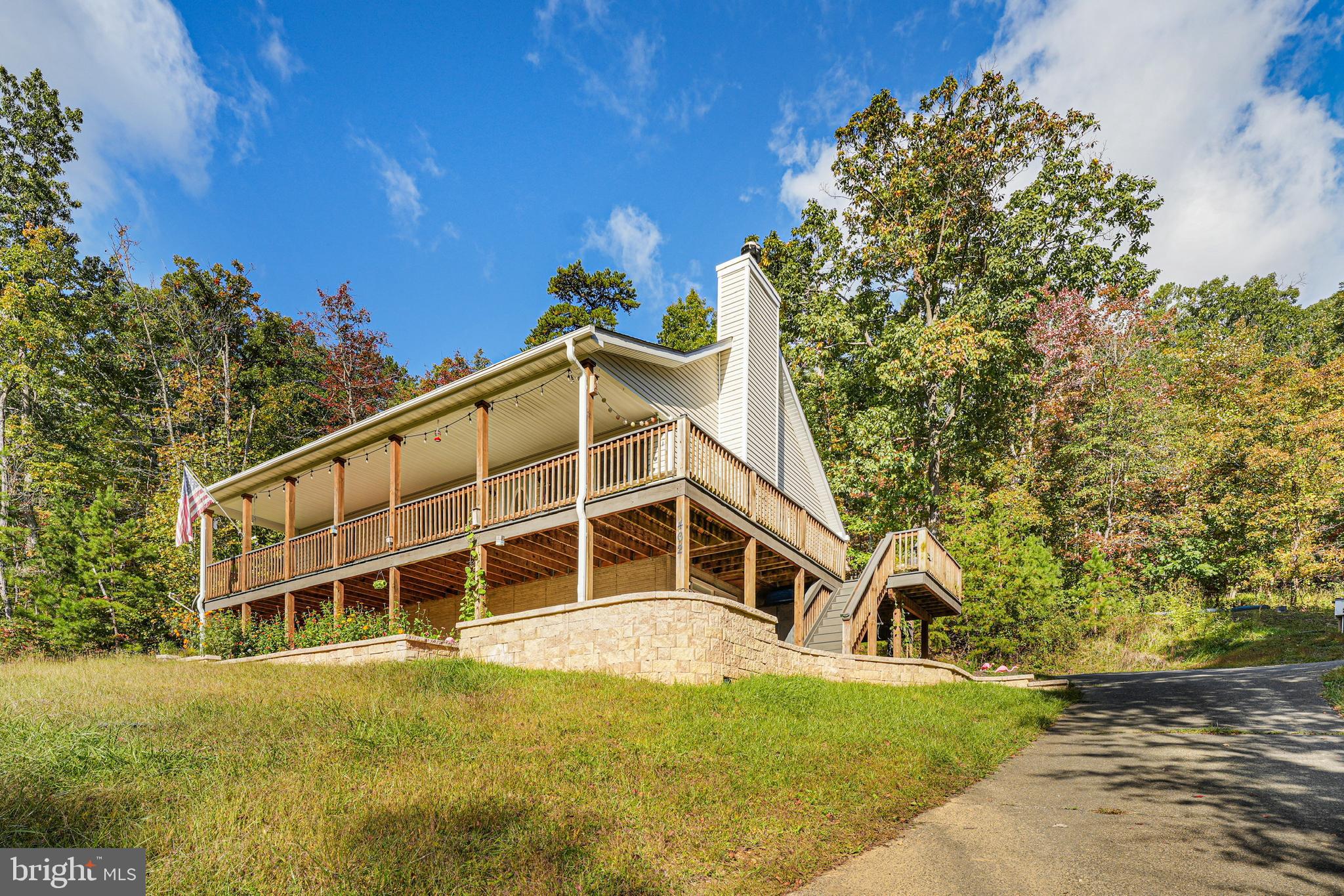 This well-built and meticulously-maintained home is tucked into a peaceful wooded setting and comes with an additional .54-acre lot (Lot 262) for a total of 1.04 acres. Unlike most homes in the area, it features a fully finished basement, long paved driveway, custom outdoor living spaces, and mountain ridge view. Built by well-known local builder (Licking Valley Construction), the home is in excellent condition.

OUTDOOR LIVING:  Off of the upper level, the 8-foot wraparound porch (fully covered along front side) is the perfect place to relax, entertain, and enjoy surrounding views and starry nights. Walk out of the basement onto the custom patio with storage shed, path to driveway, steps to front yard, and large level garden bed. Behind the home is a large sandbox/play area (would also be perfect platform for hot tub). Multiple entry doors make access convenient for family and guests.

INDOOR COMFORT: The home is defined by generous living space and practical floor plan. The upper level features full kitchen with stainless steel appliances (2021), open dining and living area with vaulted ceiling and functional wood-burning fireplace, primary bedroom suite with en suite bathroom, two additional bedrooms, and another full bath. The walkout lower level includes a second large living area with kitchenette, fourth bedroom, full bathroom, laundry room, and bonus room (to use as extra bedroom, office, or storage). Entire home recently painted with designer Sherwin Williams "Evergreen Fog" (living areas) and "Shoji White" (bedrooms).

Like all homes in the area, the house has well water (treated) and a septic system (alternative, inspected 2026). New HVAC (2026) and water softening system (2025). Basement finished (includes sump pump) and patio installed in 2022. Highest-end Leaf Guard gutter guards (2021).

Part of the Shenandoah Farms subdivision, home ownership comes with private access to several lakes on the mountain and access points to the Shenandoah river, just a short drive down the mountain. The two local country stores (each less than 5 minutes away) supply all the basics, while shopping and restaurants are easily accessible in both Front Royal and Winchester about 15-20 minutes away.