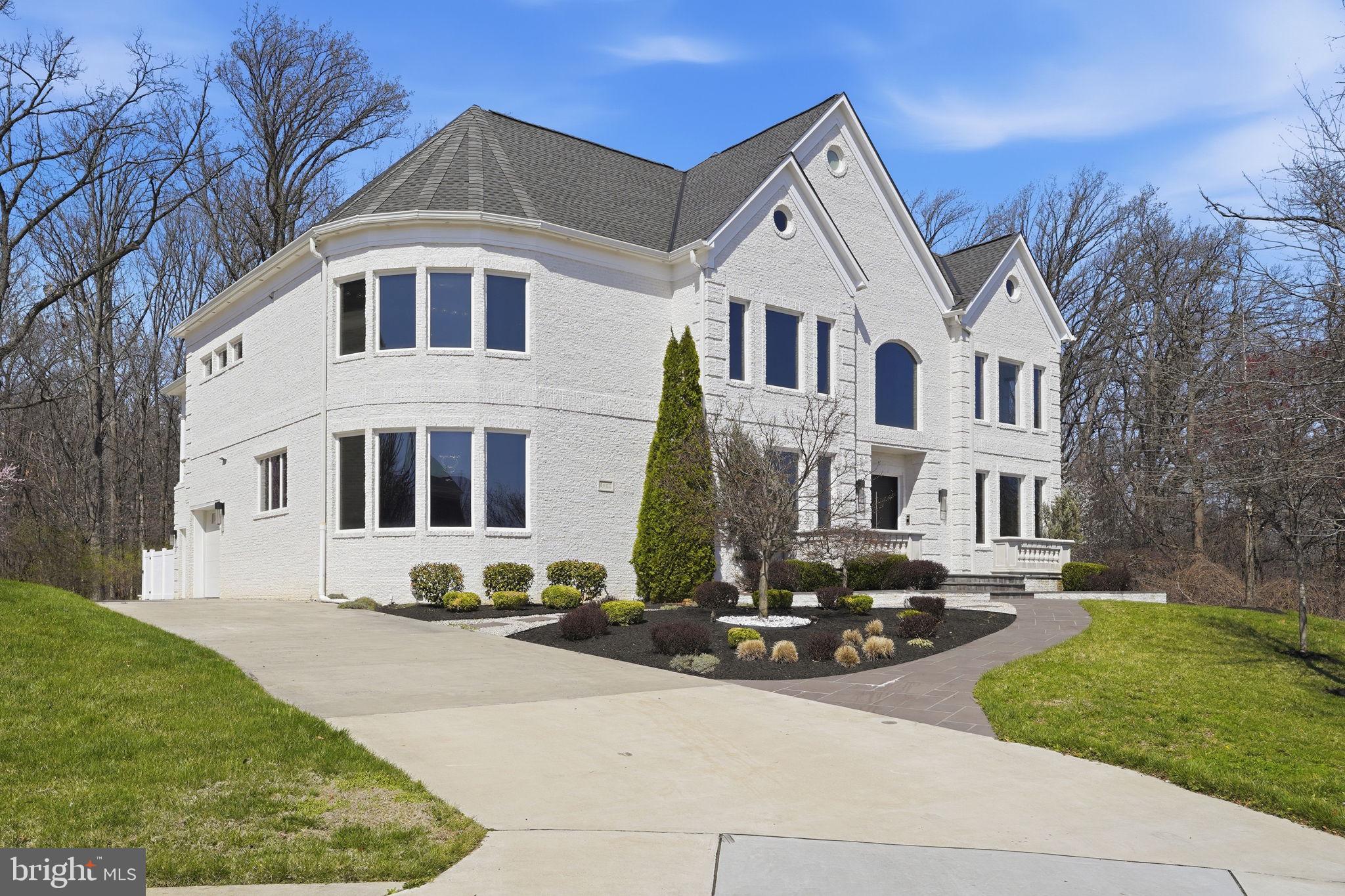 Experience a striking blend of contemporary design and refined craftsmanship in this custom residence by Potomac Custom Homes, completed in 2018 and ideally sited on a quiet cul-de-sac in The Reserves at Pinecrest. Backing to protected Fairfax County parkland, this property offers a rare combination of privacy, architectural presence, and thoughtfully curated indoor and outdoor living spaces.  Spanning nearly 10,000 square feet, this five-bedroom, six full bath home is defined by dramatic scale and modern elegance. Expansive glass elements and soaring vertical spaces create an immediate sense of openness, highlighted by 20-foot ceilings in the main living area and in the primary suite’s sitting room, with 10-foot ceilings throughout the remainder of the home. A custom floating staircase with fully enclosed glass railings extends through all levels, complemented by additional custom glass railings designed for both visual impact and enhanced safety.  Large-format Roberto Cavalli porcelain flooring flows throughout the main and upper levels, adding a cohesive and sophisticated aesthetic. Radiant heated flooring enhances comfort in select living spaces including the family room, kitchen, primary suite, primary bath, and a main-level den with direct access to the outdoor patio.  The chef’s kitchen is designed to impress, featuring custom Italian UNICA cabinetry, premium 3-inch DEKTON Aura waterfall countertops, and a professional GE Monogram appliance suite with induction range. The expansive island anchors the space, offering both functionality and a natural gathering point for everyday living and entertaining.  Throughout the home, GROHE designer fixtures and copper plumbing lines reflect a commitment to quality and longevity. A Control4 whole-home automation system provides integrated control of audio and key systems, complemented by a hardwired security system and a full-house Generac backup generator.  The home’s lower level and dedicated spaces elevate everyday living with a private home theater, golf simulator room, and a fully equipped home gym, creating a well-rounded environment for recreation and relaxation.  Outdoor living is equally impressive, designed for year-round enjoyment. A resort-style saltwater fiberglass pool is enhanced by a Pentair electric heating system, LED lighting, decorative waterfall feature, and an automatic cover. The expansive patio surrounds the pool and includes a built-in Weber gas grill, outdoor refrigerator, and integrated storage, creating a seamless outdoor entertaining experience. The upper-level primary suite extends outdoors to a private balcony retreat featuring a hot tub, offering an elevated space to unwind while overlooking the surrounding property.  Additional features include three Carrier HVAC systems for zoned climate control, a Rachio smart irrigation system with app-based weather-adaptive technology, and a spacious four-car garage with oversized eight-foot doors, epoxy-coated floors, and custom storage. A thoughtfully designed mudroom includes a built-in pet washing station for added convenience.  Located in Annandale, this home offers access to a variety of parks, golf courses, shopping, dining, and major commuter routes including I-495, I-395, Route 236, Route 7, and Braddock Road, providing connectivity while maintaining a sense of retreat.  This exceptional property brings together modern architecture, high-end finishes, and a private natural setting to create a truly distinctive living experience in Northern Virginia.