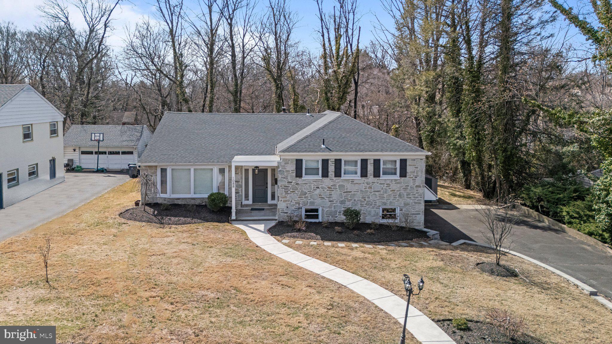 Welcome to 1088 Sparrow Road, a beautifully maintained stone, split-level home in the sought-after Jenkintown Manor neighborhood. With exceptional curb appeal, this home immediately impresses—freshly replaced curbing, a meticulously manicured lawn, and a stately front door set the stage for what lies inside.

Step into the private foyer, a welcoming space perfect for greeting guests before entering the expansive, open-concept first floor. To your left, the spacious living room features a gorgeous bay window, bathing the space in natural light. Straight ahead, the upgraded, modern kitchen boasts a fully upgraded kitchen with new cabinetry, a wall oven, quartz countertop, a spacious kitchen island, and large windows, allowing for a flood of natural light to enter. The heart of the home -- the perfect spot for gathering. The generous dining room, ideal for hosting, completes the main living space with access to the patio through sliding doors.

Upstairs, four well-appointed bedrooms await, including a primary suite with a luxurious whirlpool tub. The additional three bedrooms offer ample closet space, large windows, and plenty of room to relax. A second, upgraded full bathroom with a double-sink vanity serves this level.

The lower level is an entertainer’s dream, featuring a game room with a cozy gas fireplace, built-in cabinetry, a wet bar, and a full bathroom. The laundry room is also conveniently located here, complete with a washer, dryer, and built-in steamer.

That's not all! -- The finished basement offers additional flexible space with finished walls, ceiling, and flooring—ready to be transformed into your ideal setup. 

This home also features a side-entry two-car garage with two car-charger hookups, and a covered porch accessible from the game room, providing protection from the elements.

Prime Location! Just a mile from the SEPTA Rail Station, commuting is a breeze. Enjoy the nearby restaurants, shopping centers, movie theaters, and parks, making this a perfect location for every lifestyle.

Upgrades throughout! This meticulously cared-for home is move-in ready, with an option to purchase furniture separately.

Don’t miss this opportunity—schedule your private showing today! OPEN HOUSE SCHEDULE FOR  March 22nd AND 23rd from 1-3pm