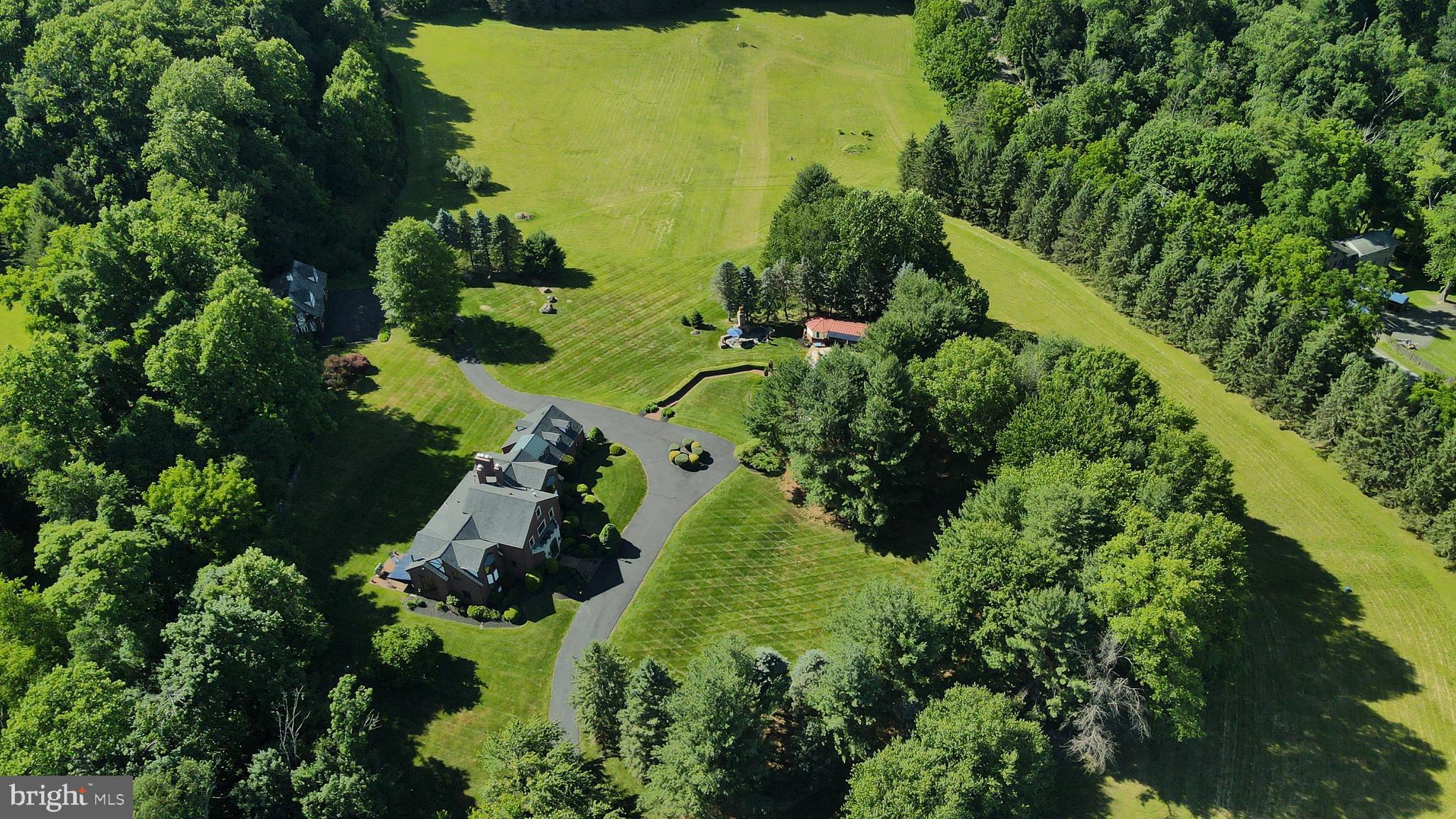 Proudly introducing Shireford, a truly extraordinary estate nestled in a coveted Chester Springs setting, where privacy, scenic beauty, and timeless Chester County character converge. Encompassing over 21 breathtaking acres across four separately deeded parcels, this remarkable property offers a rare opportunity to own a legacy estate of exceptional scale, quality, and versatility.

Arrival at formal gated entry framed by magnificent shrub beds and seasonal flowers and with first sighting of main house at a prominent elevation constructed of enduring solid brick masonry, the nearly 6,000-square-foot residence showcases enduring craftsmanship, architectural distinction, and a level of quality seldom found in today’s newer homes. A grand two-story foyer adorned with lustrous marble flooring and a spectacular Schonbek crystal chandelier sets the tone for the elegance that unfolds throughout.

Designed for both grand-scale entertaining and comfortable everyday living, the home features a dramatic sunlit two-story great room highlighted by custom oak millwork and a large wood-burning fireplace. The impressive two-story dining room, illuminated by a stunning Fine Art chandelier and opening to a private patio, creates an unforgettable setting for hosting family and friends. 

At the heart of the home, the inviting island kitchen is appointed with custom wood cabinetry and a charming wood burning fireside gathering area, seamlessly flowing into the cozy family room anchored by a handsome stone fireplace. A private first-floor ensuite provides flexible accommodations for guests or multigenerational living, while the oversized executive office/library with custom oak built-ins offers an inspiring work-from-home environment.

The luxurious primary suite serves as a private retreat, featuring a beautifully appointed bath and expansive dressing area. Three additional generously sized bedrooms and a bright natural lighted office complete the upper level, including an oversized guest suite with a private bath. A convenient second-floor laundry room adds to the home’s thoughtful design.

Beyond the residence, the estate’s outdoor amenities are equally impressive. Enjoy summer days by the resort-style inground pool with raised jacuzzi and one-meter competitive diving board, complemented by a fully equipped pool house with kitchen, expansive covered entertaining area, bathroom facilities, changing rooms and a stunning large separate eating area with an oversized stone Rumford wood burning fireplace, plus a built-in cooktop complete the pool setting complex.  An attached two car garage and a detached four-car garage with carriage house provides endless possibilities for guests, hobbies, collections, or future customization.

With its unparalleled acreage and landscape maturity and boasting an approximate 240 large evergreens (majority in excess of 50 feet), separately deeded parcels, exceptional amenities, and premier Chester Springs location,  Shireford represents a once-in-a-generation opportunity to own one of Chester County’s most distinguished estates. A property of this caliber is truly beyond compare.