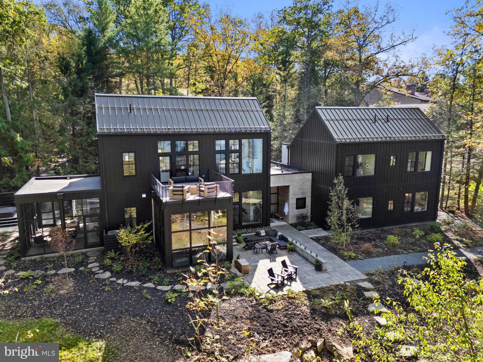 Discover The Birch Bower, a rare architect-designed lakefront sanctuary offering 600 feet of private shoreline on Deep Creek Lake. Completed in 2021, this 6-bedroom, 5.5-bath residence exemplifies modern luxury, combining meticulous design, serene natural surroundings, and proven short-term rental performance. Turnkey consideration is available with a compelling offer. This extraordinary lakefront estate presents a unique opportunity for discerning buyers seeking a distinguished and enduring retreat on Deep Creek Lake. Set on 0.39 acres with an adjoining 1.5± acre buffer strip, the property affords unparalleled privacy and ecological significance, with protected forest supporting endangered native species. Its orientation captures both sunrise and sunset, bathing the dock in coveted afternoon light. Inside, refined craftsmanship and comfort converge. The main gathering space features 11-foot ceilings, polished concrete radiant-heat floors, a sleek Spark gas linear fireplace, and a rich walnut accent wall that adds warmth and depth. A glass-enclosed prow, highlighted by a rich walnut ceiling, frames captivating lake views around a custom dining table, while Marvin Ultimate windows invite abundant natural light. Custom cabinetry throughout the home enhances both style and function. The primary suite boasts sloped 11-foot ceilings and panoramic vistas, and each guest bedroom includes a private en suite bathroom with layered soundproofing for serenity. The residence is intentionally designed to accommodate multigenerational living and flexible owner use, with the primary suite above the great room and the walk-in pantry both lockable during short-term rental stays. Outdoor spaces are designed for both relaxation and entertaining, including a private upper deck off the primary suite, a screened lower-level porch, a hot tub terrace with an outdoor shower, and an open-air lakeside terrace, each offering stunning lake views. Thoughtful outdoor lighting is incorporated throughout to enhance ambiance while protecting the night sky. The main-level accessible suite includes supportive features such as grab bars, a roll-in shower, a roll-under sink, and thoughtfully positioned light switches throughout the home. A heated, zero-threshold front entry and an ADA-compliant gravel path leading to the dock, where a safety handrail ensures secure, barrier-free access. State-of-the-art systems include four HVAC zones, a humidifier/dehumidifier serving the main gathering space, high-speed internet extending to the dock, a Kohler whole-house generator, a 2020 well, sprinkler system, and an Aircat whole-house water treatment system. 26 fully owned Tesla solar panels underscore the home’s commitment to energy efficiency and sustainable living. Tucked at the quiet end of a private lane, The Birch Bower offers rare seclusion with effortless access to Deep Creek Lake’s year-round recreation and charm. Nearby Wisp Resort provides four-season adventure with skiing, snowboarding, and mountain biking, while Swallow Falls State Park and Deep Creek Lake State Park invite exploration of pristine forests and waterfalls. Just minutes away, the lake’s marinas, artisan markets, and locally loved restaurants create a vibrant yet relaxed community atmosphere—all within a few hours of Washington, D.C., Baltimore, and Pittsburgh. Where architectural refinement meets untouched lakeside beauty, The Birch Bower emerges as one of Deep Creek Lake’s exceptional and timeless treasures.