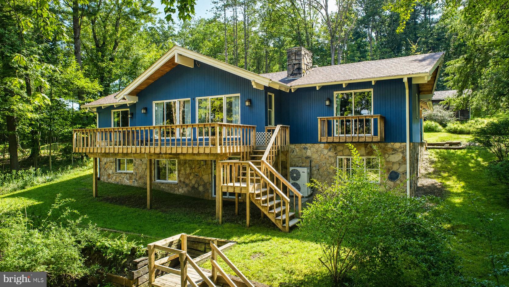Experience the best of Deep Creek Lake living from this private waterfront retreat tucked among mature trees on nearly an acre of land. With over 100 feet of lake frontage, a private Type-A dock, and a gentle distance to deep water, this property offers the kind of shoreline that's increasingly hard to find. Thoughtfully positioned to capture expansive lake views while preserving a sense of privacy, the home features a spacious rear deck perfect for taking in sunsets, entertaining guests, or simply enjoying the peaceful surroundings. Inside, warm wood accents, exposed beams, and an open-concept layout create a welcoming lakehouse atmosphere. The finished walkout lower level provides additional living and recreation space, making it ideal for hosting family and friends. Conveniently located near the area's most popular attractions, dining, and recreation, this well-cared-for home offers the perfect opportunity to enjoy Deep Creek Lake today while leaving room to make it your own for years to come.