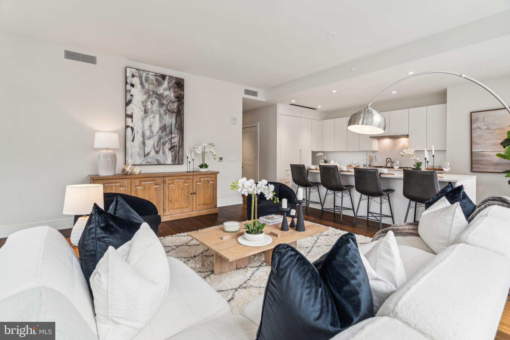 Arthaus, a commanding residential high-rise in Philadelphia’s performing arts district, proudly presents Residence 802—a stunning 2-bedroom, 2-bath, 1,598 SF single-level home with City Hall and skyline views, offered at $1,350,000. This maintenance-free, move-in-ready residence combines refined interior design, resort-level amenities, and white-glove services. Tax abatement available. Ideal for busy professionals, retirees, or global travelers—Unit 802 is a must-see.

Arthaus impresses from the moment you arrive. A tall solid-wood entry door with elegant hardware opens to a spacious, light-filled foyer with a large walk-in coat closet, hallway bath, and in-unit laundry. The expansive great room showcases panoramic city views and a seamless blend of kitchen, living, and dining spaces, highlighted by soaring ceilings, floor-to-ceiling windows, wide-plank Havwood flooring, and a weather-protected walk-out balcony. Bathed in natural light, the space feels bright, airy, and far larger than its footprint suggests.

The chef’s kitchen is designed for effortless entertaining, featuring a large center island with seating for four. Sleek polar white matte Poggenpohl cabinetry, Super White quartz countertops and backsplash, and a fully integrated, high-end stainless appliance package—including Wolf, Sub-Zero, Bosch, and Asko—create a clean, seamless aesthetic.

The primary suite and guest bedroom are thoughtfully positioned on the east side of the residence. The guest bedroom offers a quiet retreat with mid-town views and a walk-in closet. The adjacent hall bath is finished with Calacatta porcelain tile floors, Super White quartz countertops, and polar white Poggenpohl cabinetry.
The owner’s suite is wrapped in 10' floor-to-ceiling windows and features an oversized walk-in closet. The spa-inspired bath includes a Badeloft soaking tub, double vanity with Robern mirrors, Super White quartz marble, Contempo white marble floors and shower tile, and a Kohler toilet closet.

Arthaus is a modern architectural masterpiece by renowned developer Carl Dranoff, designed by Kohn Pedersen Fox and built by Intech Construction. Wellness is central to the experience, from the Monet-inspired lobby mosaic to the private sixth- and seventh-floor resort featuring a pool, fitness center, spa, salon, pet park, outdoor terraces, lawns, and gardens.

White-glove services include 24-hour doorman, concierge, chauffeured town car, and valet parking. The home includes one parking license. With the tax abatement, estimated annual real estate taxes are approximately $2,745