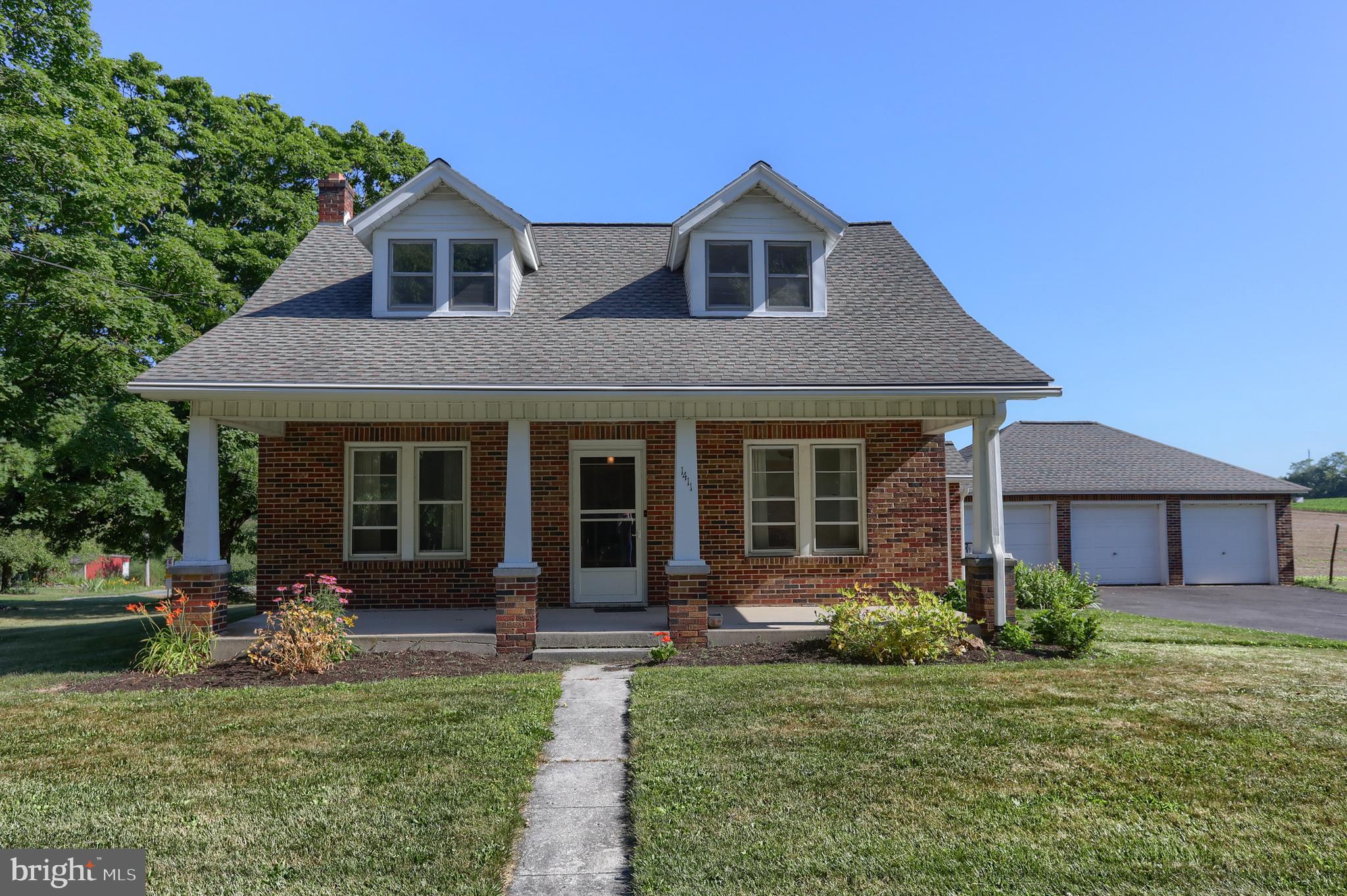 COUNTRY SETTING with HALF AN ACRE.  Classic brick Cape Cod-style home situated on 0.50 acre, featuring a 3-car detached garage.   Step inside and discover original hardwood flooring in many rooms.  The main level features a welcoming entry foyer with open staircase leading to the 2nd floor, (2) front living rooms, dining room, kitchen, full bath, laundry room, and (1) main-level bedroom.  The upper floor holds (4) hall-entered bedrooms each with original hardwood flooring. The main level bath has been updated with flooring, vanity, mirror, lighting, and shower surround.  The level backyard will be a great spot for family gatherings and picnics.  Bring your comfortable outdoor furniture for the 8 x 30 covered front porch. Enjoy the convenience of a (3) car detached garage.  Showings may begin Sunday, June 28th.  Schedule your tour today!