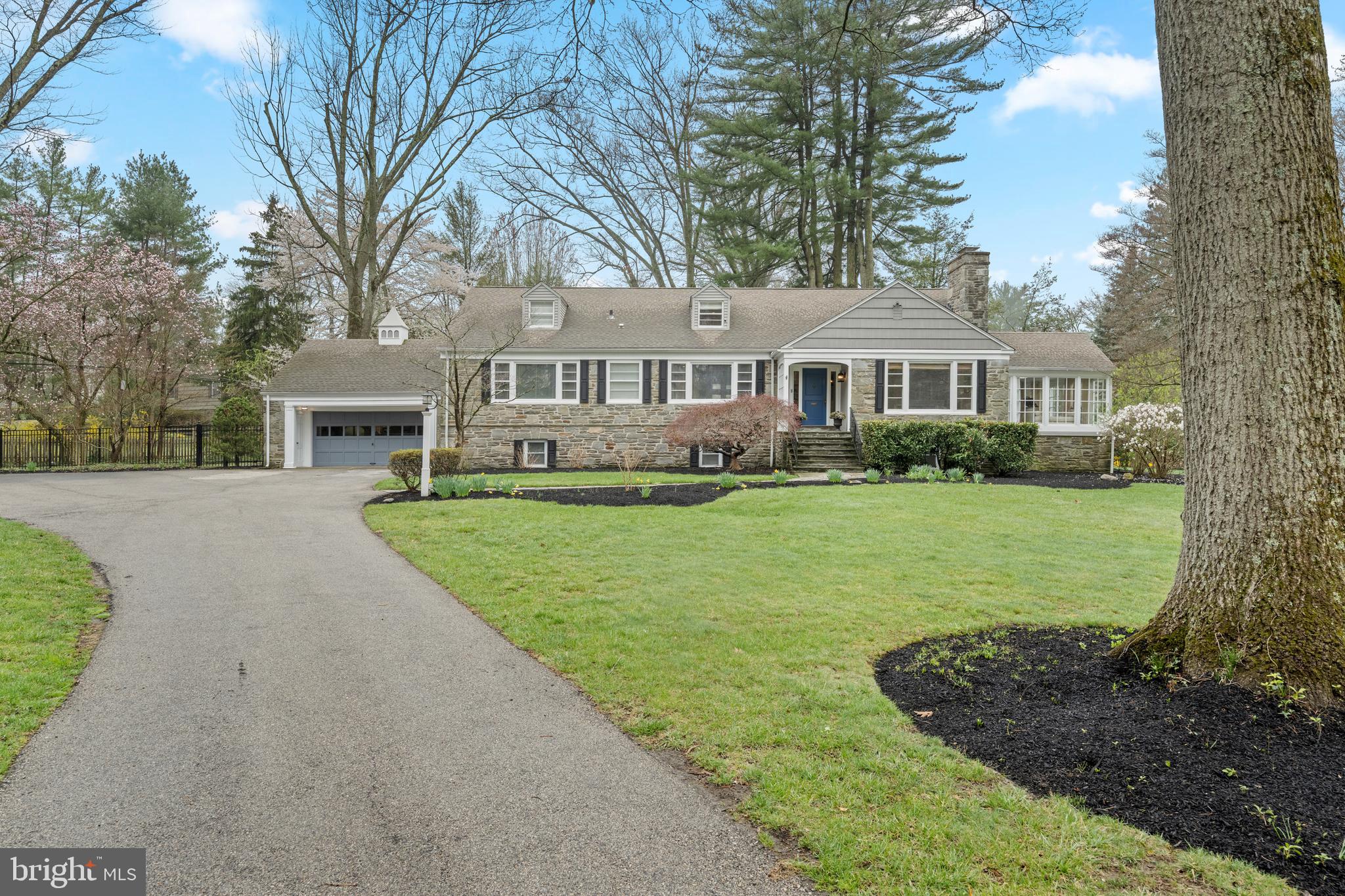 A picturesque and turnkey gem in one of Lower Merion's most sought-after neighborhoods. Welcome to 316 McClenaghan Mill Road, built by Mahoney Builders. This gorgeous 5 bedroom, 3 full/1 half-bathroom stone cape colonial is situated on a .95 acre premier corner lot.  In addition to its ultra convenient location, this home is also in the high school choice zone of the Lower Merion School District! In 2025, the entire exterior was freshly painted (siding, doors and garage door), and new shutters and professional uplighting were installed.  As you walk up the stone path and enter the home, prepare to fall in love! Inside, the gracious classic spaces have been thoughtfully updated.  Gleaming refinished oak floors run throughout the first floor.  Enter the welcoming foyer, and to the right is an extra-large living room featuring a beautiful wood-burning fireplace and the finest moldings. This living room flows directly into a sunlit dining room. Off of this living room is also a seasonal light-filled porch with full glass windows.  The back of the home flows openly into a large eat-in kitchen, which was recently updated with freshly painted white cabinets, new quartz countertops, and all new appliances (2025). The kitchen also has a white tile backsplash, a butler's pantry with a sink, under-cabinet lighting and ample storage. Directly off the kitchen is an enormous family room offering vaulted ceilings and abundant light. This "great" room boasts custom built-in cabinetry/shelving, a beautifully pointed stone wood-burning fireplace, custom Anderson windows and doors, and skylights. Open the glass doors directly out to the tiered deck to your very own private, tranquil oasis completely fenced in! This space is perfect for a quiet relaxing evening, or a summer barbecue! The main floor also has a large primary bedroom, with generous closet space. The ensuite bathroom includes an oversized shower, a porcelain tile floor that extends to the shower walls, and a white double vanity with Carrara marble countertops! There are two additional bedrooms and a newly renovated full bathroom on the first floor (2024.)  With so much functional space in this home, the current owners used one of these bedrooms as an office. The second floor has two extra large bedrooms and a Jack and Jill bathroom.  The large lower level offers great potential and additional living space, complete with a powder room and laundry area. The lower level will also lead you to the attached garage. 316 McClenaghan Mill Road is in an ultra-convenient location with just over a mile walk to Suburban Square, Trader Joe's, Whole Foods, and two different SEPTA stations making it a commuter's dream! This absolute GEM is close to everything and has it ALL!