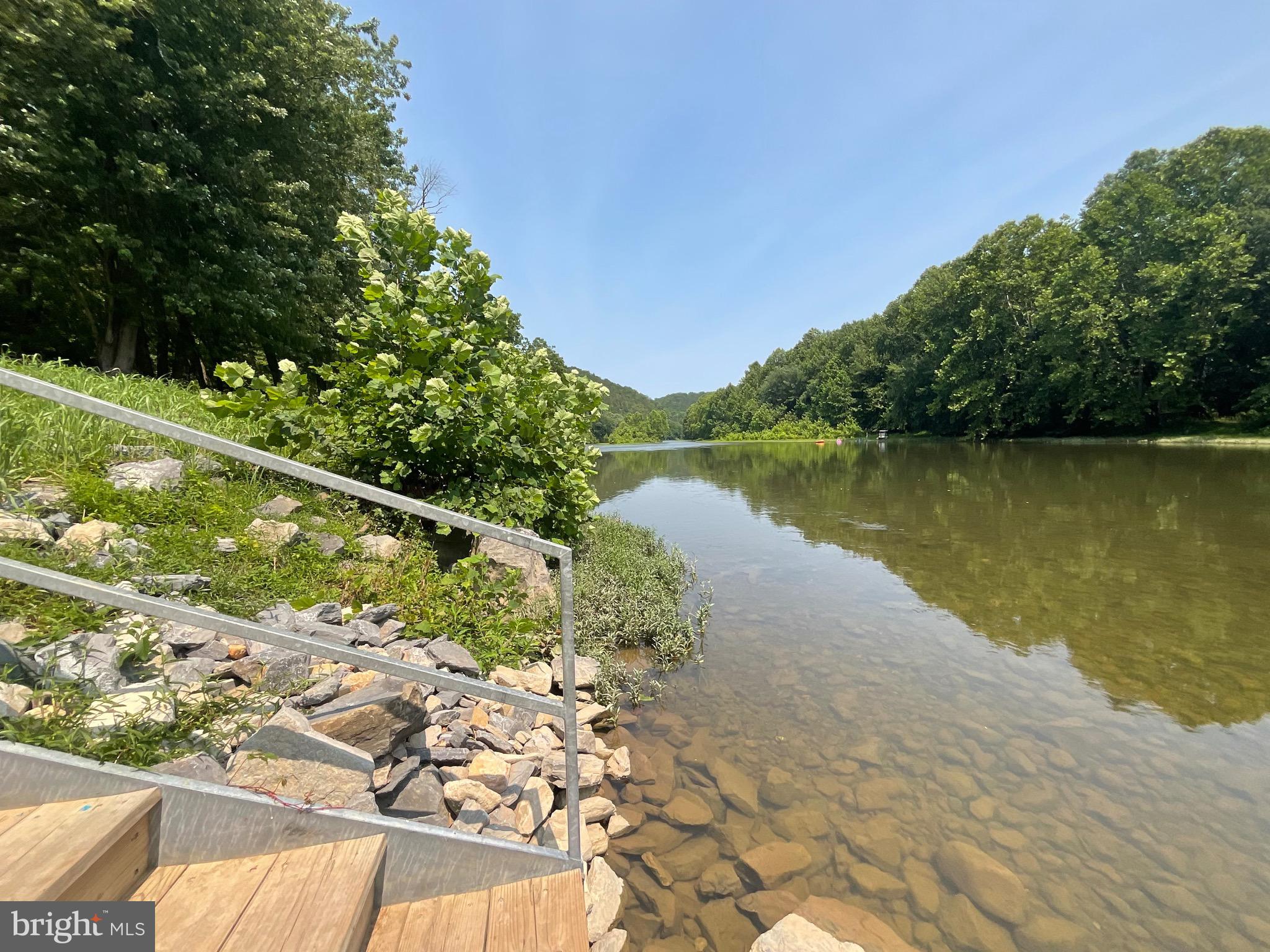 NOW 'S THE TIME TO ENJOY THE BLUFFS OF THE POTOMAC WITH A SECTION OF THE RIVER RESERVED ONLY THE LANDOWNERS. WIDE STEPS LEAD DOWN TO THE RIVER...FLOATING, SWIMMING OR KAYAKING!  NO NEED TO GET OUT TO OPEN THE GATES AS IT'S ACCESSIBLE WITH  ELECTRONIC  GATES.  YOU'LL SEE PICNIC TABLES SCATTERED ALONG THE RIVER AND SEVERAL GRILLING STATIONS.  THE USABLE  20 ACRE LOT IS GREAT FOR HIKING. INCLUDED IS A 2026 CAMPER  WHICH IS FULLY EQUIPPED AND EASILY SLEEPS 4.   INCLUDED IS THE 2024 KAWASKI MULE.   THE PRIVATE SETTING ALSO HAS A PICNIC TABLE TO GRILL, ROAST MARSHMELLOWS  OR ENJOY A CAMP-FIRE AS YOU  ENJOY THE    QUIET & SECLUDED SETTING.  THE CAMPER IS A RECENT PURCHASE, WHICH ALSO CONVEYS, FULLY EQUIPED AND EASILY SLEEPS 4.  THE PICNIC TABLE SETS 6-8. THERE'S PLENTY OF WOOD FOR THE  STONE FIRE PIT...PERFECT FOR GRILLING HAMBURGERS  &  HOT DOGS  &  ROASTING MARSHMELLOWS.  ATV'S WIND THROUGH SUBDIVISION  IN THE SPRING, SUMMER & FALL, OFTEN MEETING AT THE RIVER.  THE GATED BLUFFS OF THE POTOMAC RIVER SUBDIVISION IS FOR THE OWNERS & FRIENDS & FAMILY TO ENJOY.