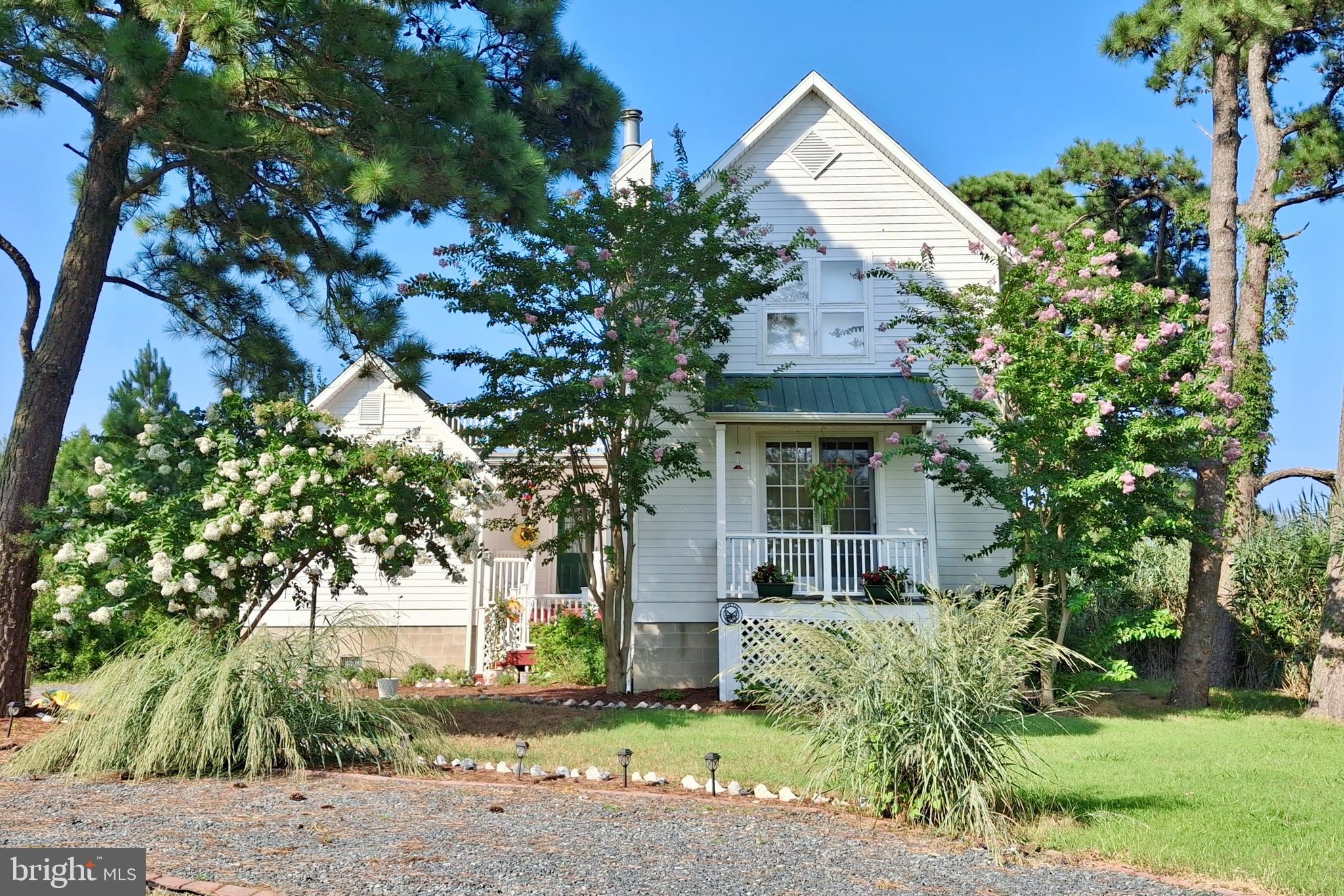 Welcome to your private coastal retreat on Chincoteague Island, where relaxed island living, bay glimpses, and natural surroundings create a peaceful and inviting escape.

Set on two lots totaling .647 acres, this property offers exceptional privacy with mature trees, native landscaping, and frequent visits from local wildlife including deer, shorebirds, and other coastal species that make this area so special.

A charming front porch welcomes you inside to a light-filled interior featuring a dramatic two-story living room with soaring ceilings, hardwood floors, and a new propane fireplace that adds warmth, comfort, and an inviting focal point to the space. Sunlight filters beautifully through decorative windows, adding character and a truly unique feel. The open floorplan flows effortlessly into the dining area and kitchen, making it ideal for both everyday living and entertaining.

The first-floor primary suite provides comfort and convenience, while upstairs features an additional bedroom with vaulted ceilings and an airy loft—perfect as a flexible space for guests, a home office, studio, or additional living area.

Outdoor living is a standout feature. Enjoy the spacious screened porch for shaded relaxation, unwind on the welcoming front porch, or head up to the expansive rooftop deck—perfect for enjoying coastal breezes and peaceful water views. The generous yard offers room to spread out, while the natural setting provides a quiet, tucked-away feel. A storage shed adds everyday functionality.

Offered partially furnished, this home is ready to enjoy right away—whether as a full-time residence, second home, or vacation getaway.

Chincoteague Island offers a unique blend of laid-back coastal living and natural beauty, surrounded by the waters of Chincoteague Bay and the protected landscapes of the Chincoteague National Wildlife Refuge. Known for its famous wild ponies and unspoiled beaches on nearby Assateague Island, the area is a haven for nature lovers, boaters, and outdoor enthusiasts. Enjoy fishing, kayaking, crabbing, biking trails, waterfront dining, and charming local shops, with the added bonus of rocket launches from nearby Wallops Island.

If you’re looking for privacy, character, and a true connection to nature—this Chincoteague property delivers.