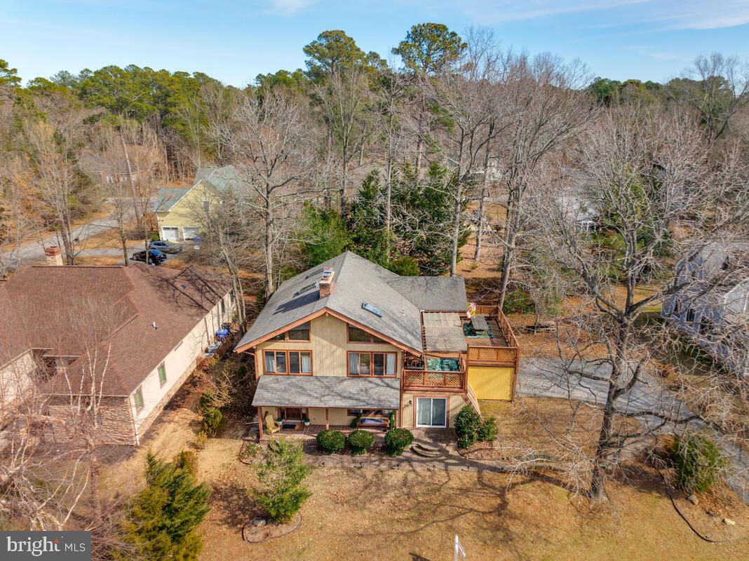 This Post and Beam, Mid-Century Modern coastal home sits parallel to the Potomac River, offering a connection to the water and a lifestyle of relaxation. The upper level is centered around an expansive Great Room where high vaulted ceilings show off the beams and soaring architectural lines meet partial river views and a cozy fireplace. This space flows into a beautifully updated kitchen equipped with all-new appliances, making it an ideal setup for any home chef. The primary bedroom serves as a true sanctuary, complete with its own private fireplace, wood-beamed ceiling and ensuite bathroom. Rounding out the top floor is an adorable sun-room and expansive decking, offering the perfect spots to soak in the sun or enjoy alfresco entertaining with a view.
The lower level is dedicated to luxury and wellness, offering a versatile space for both guests and relaxation. In addition to two spacious bedrooms and a comfortable family room featuring its own fireplace, this floor houses a dedicated indoor spa room. This private retreat allows you to enjoy a soak in the indoor hot tub or unwind in the sauna, all while enjoying the comfort of heated tile flooring that runs throughout the spa bath area. Beyond the home, you will experience resort living at its finest in a premier community located just 90 minutes from Washington, D.C. Residents enjoy a vacation-like lifestyle every day with access to an 18-hole golf course, a driving range with a pro shop, a clubhouse, a community pool, tennis and pickle ball courts, and a full-service marina.