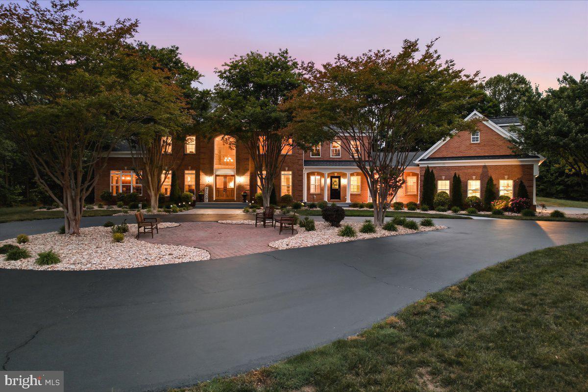 BIG NEWS!!  PROMOTIONAL PRICING AND BUYER BONUS OF $20,000 to buy-down your interest rate with August 2026 settlement! Purchase this custom built estate home now, packed with amenities, resort-style backyard, extensive workshop and garage space on 2 private acres. The 8600+ SF home was  designed for large-scale entertaining, multi-generational living and luxury everyday in the heart of mid-Calvert County.  UTILITIES are low; current average for all is $485/mo!! The location is within 10 minutes to Solomons Island, 5 minutes to Nan’s Cove boat launch. For car enthusiasts, hobbyists, contractors, small business owners, or anyone needing serious storage and workspace, the property includes two detached outbuildings with four additional garage bays, workshop space, water, electric, and slab foundations. The home itself has a thoughtfully designed main level, featuring a private guest wing with a separate entrance and private screened porch, independent yet still connected to the heart of the home. The expansive floorplan includes a gourmet eat-in kitchen, large dining room, an executive office with custom wood accent walls, spacious family room, a stunning morning room with soaring 12-foot ceilings and marble flooring. Hardwood floors span most of the main level. Upstairs, the luxurious owner’s retreat is gorgeous with tray ceilings, fireplace, coffee bar. Three additional oversized bedrooms and two full baths complete the upper level. The fully finished walk-up lower level was built for entertaining and flexible living, featuring a second full kitchen, media room, billiards area, built-in entertainment space, a fourth fireplace, and a full bath with a tiled shower—ideal for pool access, guest overflow, or separate lower-level living arrangements. The outdoor living space centers around a stunning 20'x40' heated pool with a tanning shelf, diving board, stone waterfall, and expansive patio spaces designed for unforgettable gatherings. Two oversized pavilions create the ultimate setup for outdoor entertaining, celebrations, cookouts, and summer weekends at home. A separate fenced pet area adds even more convenience. This is more than a home—it’s a rare opportunity to own a private family compound-style estate with luxury amenities, flexible living options, and unmatched entertaining potential. Home warranty conveys.