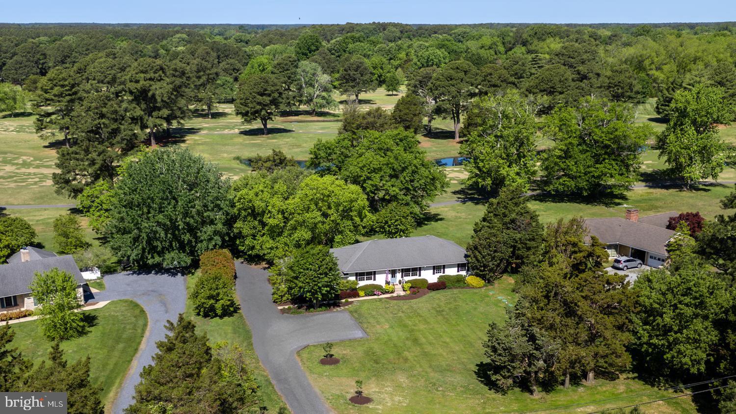 Positioned along the picturesque 5th fairway of the prestigious Talbot Country Club, this comprehensively renovated Easton residence blends timeless Eastern Shore charm with elevated modern design.   Privately set on beautifully landscaped grounds with sweeping golf course vistas, the property offers refined one-level living in one of Talbot County’s most desirable country club settings. Thoughtfully reimagined from top to bottom, the home showcases a sophisticated, light-filled interior highlighted by white oak hardwood flooring throughout, curated West Elm lighting, custom millwork, and seamless indoor-outdoor flow.   A dramatic 15-foot sliding glass door anchors the rear living spaces, opening effortlessly to the expansive terrace and manicured grounds beyond. At the center of the home is a stunning designer kitchen featuring Borghini Gold quartz countertops, custom cabinetry, premium GE Profile appliances, a 36-inch Verona range, beverage refrigeration, floating wood shelving, and an oversized center island designed for both entertaining and everyday living.   Kohler faucets and fixtures throughout the home further elevate the carefully curated finish package. The gracious living room is centered around a striking marble fireplace surround with custom built-ins, creating a warm yet sophisticated focal point for gathering and entertaining.   The thoughtfully designed floor plan offers generously sized bedrooms, beautifully renovated baths, and a spacious primary suite retreat with a boutique hotel feel. Beyond the cosmetic renovation, the property also benefits from a brand-new septic system and freshly refreshed gravel driveway, providing both style and peace of mind in equal measure. Combining understated luxury, turnkey condition, and premier golf course positioning just minutes from downtown Easton’s celebrated restaurants, boutiques, galleries, and waterfront amenities, this exceptional offering captures the very best of Eastern Shore living.