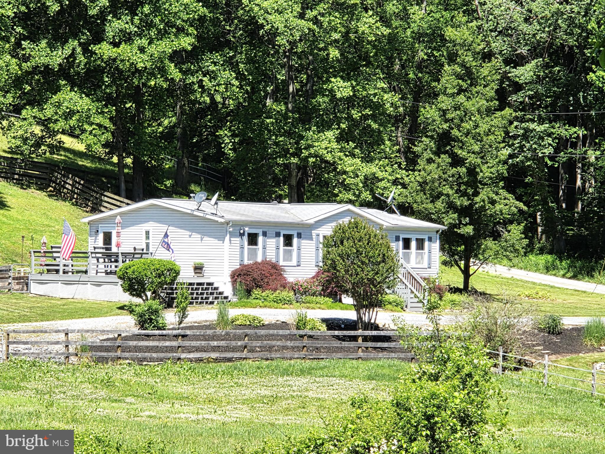 Enjoy peaceful country living on this private 5+ acre farmette located primarily in Whiteford, Maryland, with a small portion of the property extending into York County, Pennsylvania. Surrounded by mature trees and open pasture, this secluded property offers a rare combination of comfort, functionality, and privacy with no visible neighboring homes.  The manufactured home features 1,296 square feet of main level living with 3 bedrooms and 2 full baths. It has been meticulously maintained throughout the years and tastefully updated.  The living room flows into the dining room and kitchen giving it a very open feel.  The kitchen has new stainless steel appliances and oak cabinets.  The living room and primary bedroom have been updated with LVP flooring.  The bathrooms have been recently updated with the primary including a shower stall, vanity with double sinks and granite countertop.  The layout of the home provides privacy as the primary bedroom and other 2 bedrooms are separated by the living room.  The laundry room conveniently located off the primary bathroom.   Off the side door is a huge deck, great for grilling or entertaining and in the rear is a patio accented by a stone retaining wall and surrounded by a fenced in yard which backs to trees.  Additional updates within the last year are a new HVAC and hot water heater. A whole-house generator adds additional convenience and peace of mind.   Equestrian and hobby farm amenities include a barn with 6 stalls, feed room, tack room, and loft storage area. The property also offers 4 fenced pasture fields, 2 paddocks, riding ring, and a run-in shed located in one of the pastures.  Partially wooded and exceptionally private, this property offers the opportunity to enjoy rural living while located within reasonable proximity to parks, local markets, and regional commuter routes.