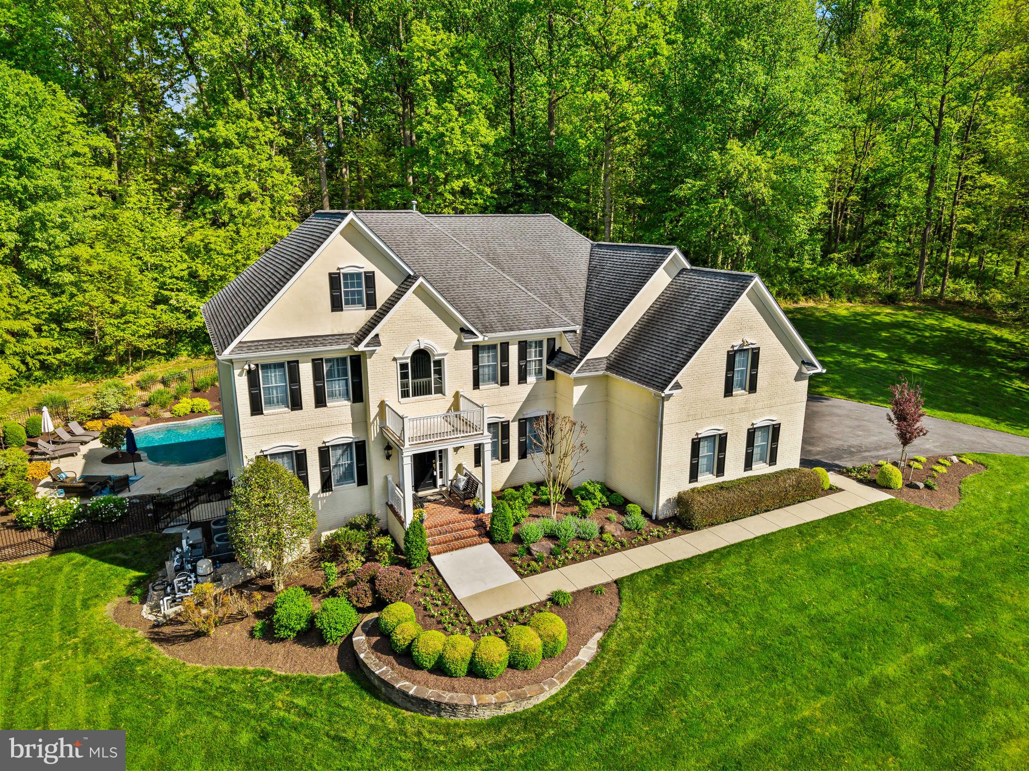Tucked into sought-after Quarterfield, 11607 Whitetail Lane offers an exceptional blend of timeless elegance, thoughtful updates, and resort-style living in the heart of Ellicott City. The main level welcomes you with rich hardwood flooring, on-trend paint, and refined finishes throughout. Formal living and dining rooms provide the perfect setting for entertaining, highlighted by crown molding and a tray ceiling in the dining room. The well-appointed kitchen features maple cabinetry, granite countertops, upgraded stainless steel appliances, and a bright breakfast room filled with natural light. Just beyond, the impressive two-story family room makes a lasting impression with custom built-ins, a cozy gas fireplace, and a dramatic wall of windows overlooking the stunning backyard. A private main-level office with rich wood paneling is perfect for working from home.   A convenient half bath and laundry room complete the main level.  Upstairs, you’ll find four generously sized bedrooms and three beautifully updated full baths. The luxurious primary suite is a true retreat, boasting an enviable walk-in closet and a spa-inspired, fully remodeled bath with heated tile floors, a freestanding soaking tub, frameless glass shower, and dual quartz-topped vanity.
The walk-out lower level expands your living space with a large recreation room, built-in office nook, dedicated movie room, fifth bedroom, and full bath—ideal for guests or multi-generational living.
Step outside to your own private oasis. The resort-style backyard features a heated saltwater pool and spa, bluestone patio, and extensive professional landscaping—perfect for both relaxing and entertaining.
Ideally located in a peaceful setting yet just minutes from the shopping, dining, and amenities of Ellicott City and Clarksville, this home also offers access to top-rated Howard County public schools, including Marriotts Ridge High School. A rare opportunity to enjoy luxury, comfort, and convenience all in one exceptional property.