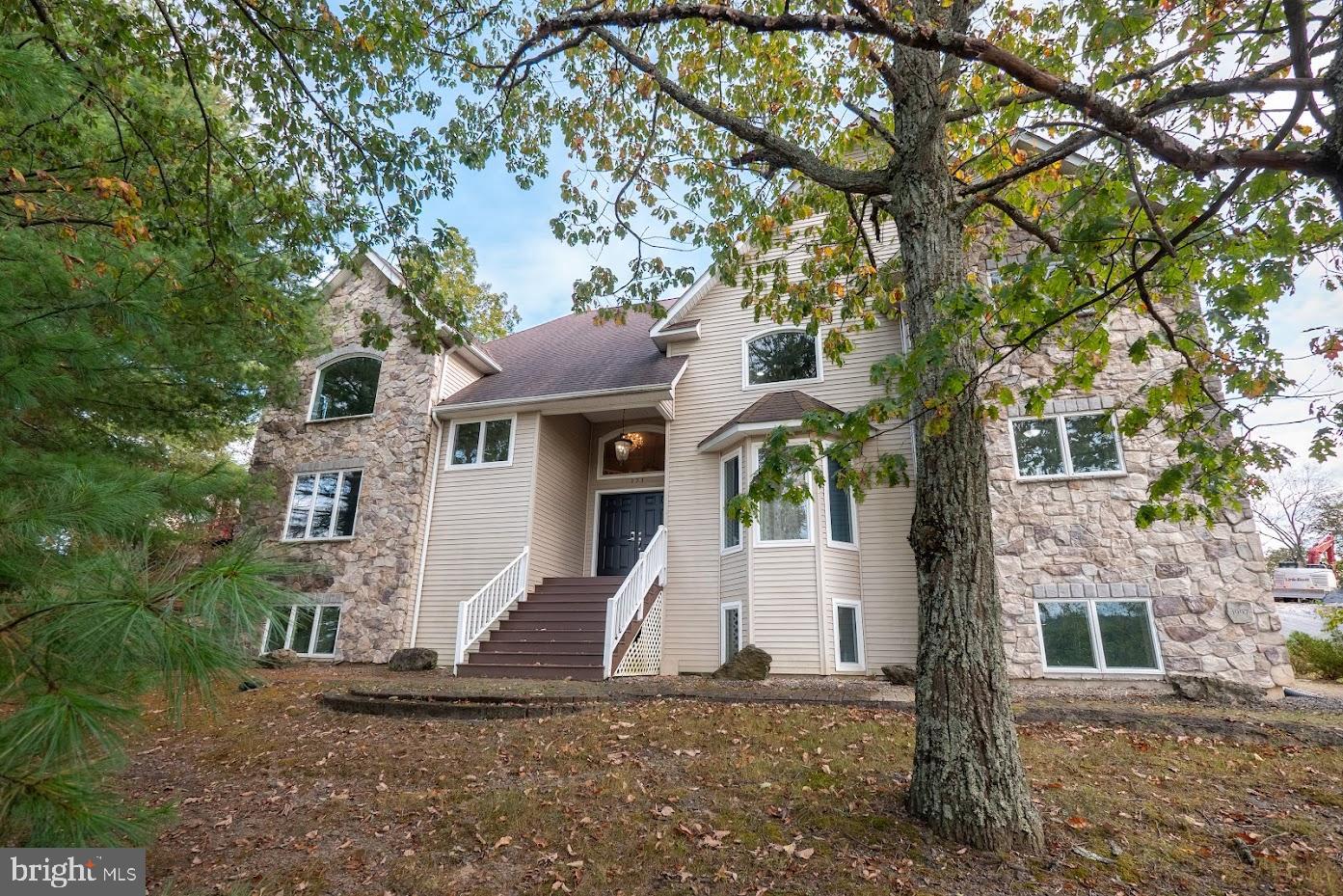 INCOME-GENERATING OPPORTUNITY – IDEAL FOR LONG-TERM RENTAL OR SHARED LIVING – Located in the desirable Country Club of the Poconos community, this expansive 5+ bedroom property offers a rare combination of size, layout, and flexibility—well-suited for investors seeking consistent rental income. The home’s layout lends itself to maximizing occupancy, with multiple bedroom suites, including a first-floor en-suite, and several private living areas throughout. The spacious eat-in kitchen with granite countertops, stainless steel appliances, and oversized island flows into a formal dining area, supporting larger households and shared living arrangements. Cathedral ceilings, skylights, and expansive windows bring in abundant natural light, enhancing overall tenant appeal. Fireplaces throughout add comfort and character, increasing long-term desirability. The fully finished walk-out lower level provides additional income potential, featuring a second kitchen, wet bar, separate living area, and multiple bonus rooms—ideal for extended living quarters, private space for tenants, or flexible use configurations.  Recent HVAC upgrades (new indoor and outdoor units) ensure efficient heating and cooling. Additional features include a two-car garage, expanded driveway for multiple vehicles, central vacuum, and hardwood and bamboo flooring throughout—minimizing future upgrade costs.  Large deck with multiple access points adds valuable outdoor living space.  Conveniently located near Route 80, offering accessibility for commuters. Community amenities—including pool, lakes, tennis courts, playground, and golf course access—support strong long-term rental demand.  With its size, multi-level layout, and multiple living areas, this property presents an excellent opportunity for stabilized rental income, including potential for room-by-room leasing where permitted.