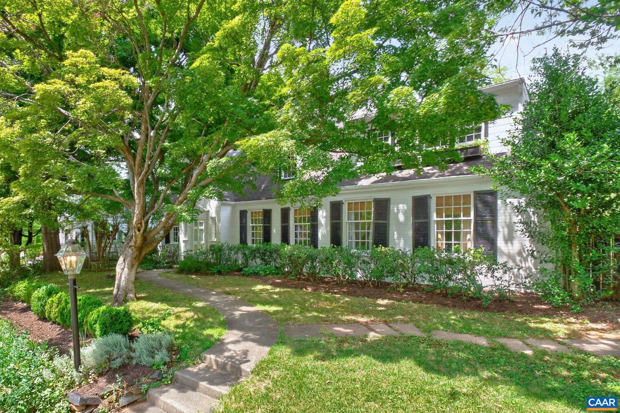 Timeless storybook Cape Cod nestled on a treasured sidewalk-lined street in the heart of Rugby, walking distance to the Rotunda. Picturesque streetscape welcomes you inside this brick home to a gracious floor plan designed for everyday living and effortless entertaining. Main level features a spacious bedroom suite and private study complete with a full bath offering the flexibility of two main-level bedrooms if desired. Sitting room and elegant dining room opens to a flagstone screened patio overlooking a lush, fully-fenced yard of English gardens. A charming Dutch door separates the mud room from the chef's kitchen complete with gas cooking and breakfast nook with built-in bench.  Gather in the living room where a wood-burning fireplace and bespoke built-ins provide the perfect backdrop. Upstairs, four bedrooms offer exceptional flexibility including an owners wing featuring spa-like bath and a bookcase secret door to the dressing room closet. Enjoy your morning coffee on the private balcony with retractable canopy and chippendale railing. Enchanting, professionally-designed outdoor spaces including garden-side terraces, climbing ivy, fire pit area, privet hedges & blooming shrubs.,Glass Front Cabinets,Wood Cabinets,Fireplace in Living Room